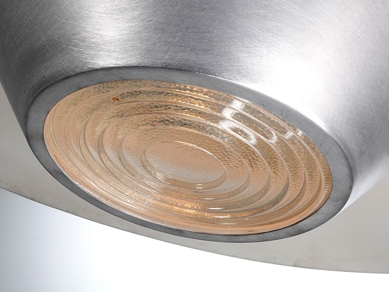 Il s'agit d'un lustre à l'aspect très spectaculaire. L'abat-jour surdimensionné en forme de dôme peu profond a un diamètre de 3 pieds et est en aluminium filé. En dessous se trouve un abat-jour en aluminium brillant inversé avec une lentille en