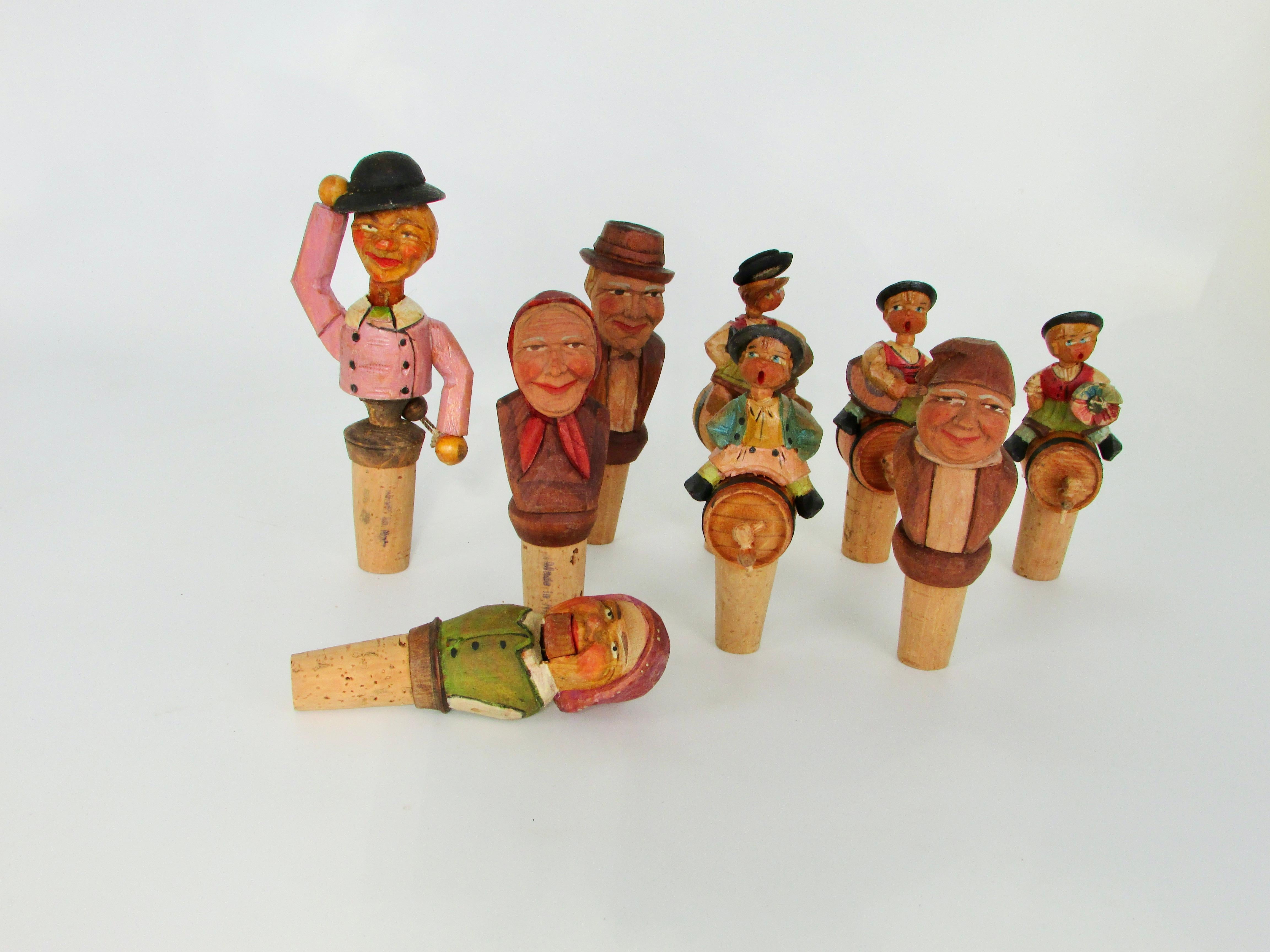 Nice collection of nine Anri carved bottle topper corks . All are full of color and character . Two are mechanical . One opens his mouth sticks out tongue . One tips his hat . Nice condition most likely never used . 