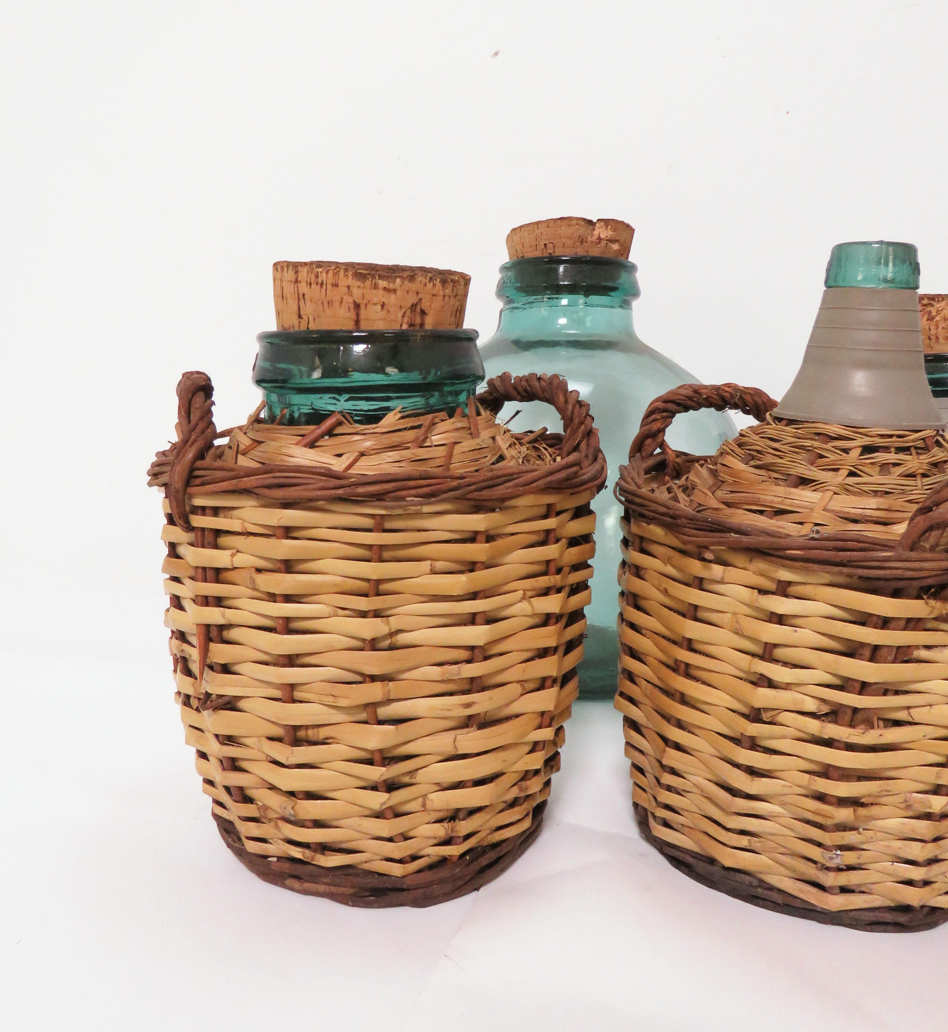 Collection of seven demijohns or carboys, most in original baskets, by Viresa, France, circa 1930s-1940s. Various sizes ranging from the largest one (in a basket), measures: 16