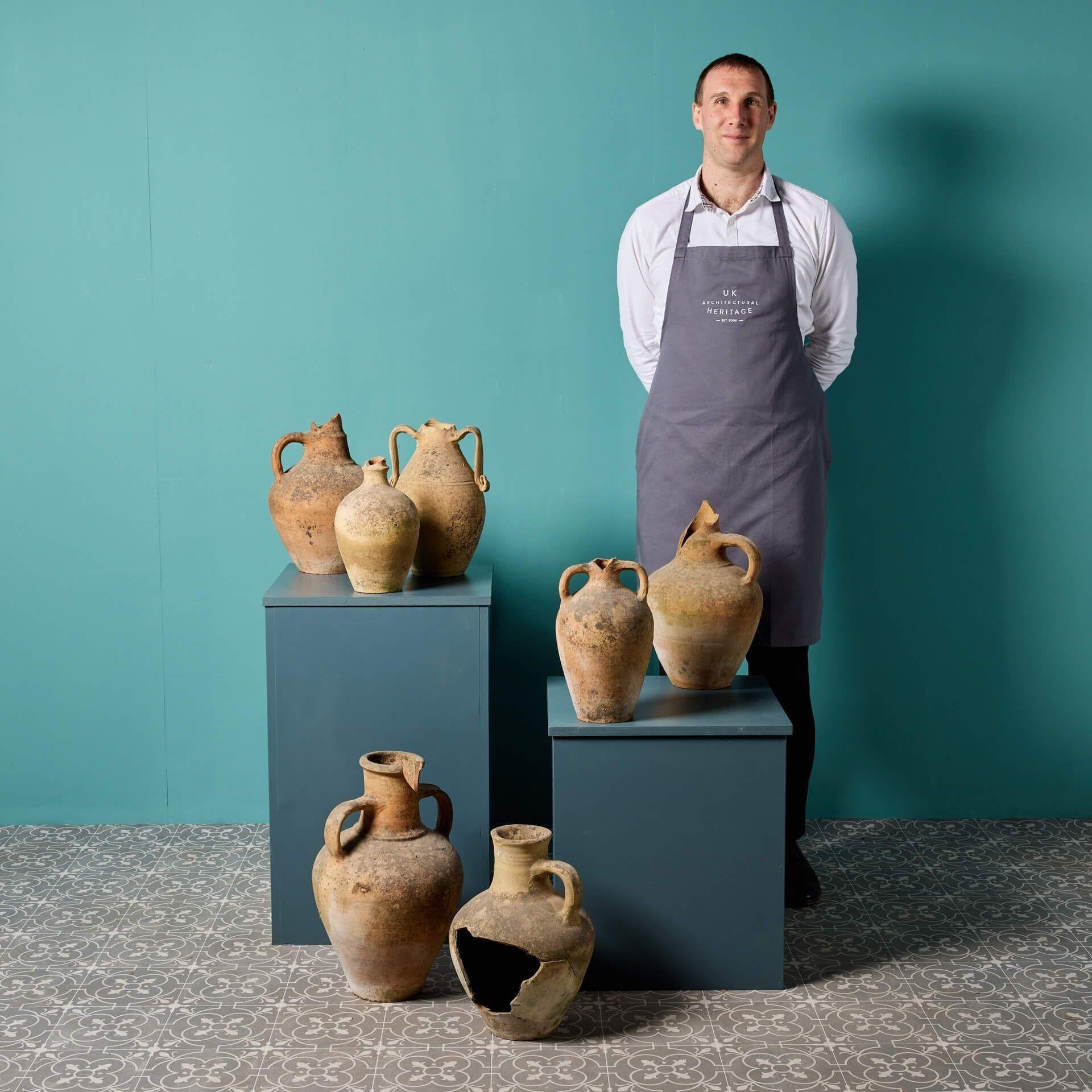 Una collezione di sette vasi in terracotta mediterranei per la conservazione degli alimenti o delle olive. Questa collezione, caratterizzata da un aspetto caratteristico e dalle intemperie, è piuttosto insolita e spicca in qualsiasi