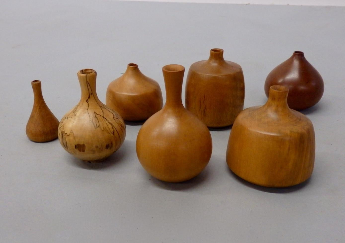 Seven Osolnik turned wood weed pots. Selection of woods and shapes. Smallest being 2.25 tall Largest just under four tall. All signed all excellent. Olivewood, elm, cherry, apple, holly, gum, smallest looks like coconut.