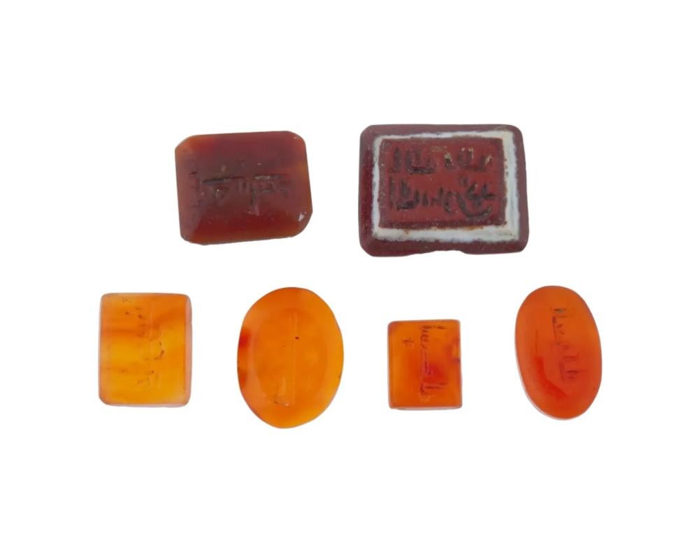A lot of three ancient Roman colorful intaglio seals. Circa 1st to 3rd centuries AD. The two pieces are crafted from carnelian and feature a hand carved image of the god Mercury wearing a winged helmet and holding a staff. The third intaglio depicts
