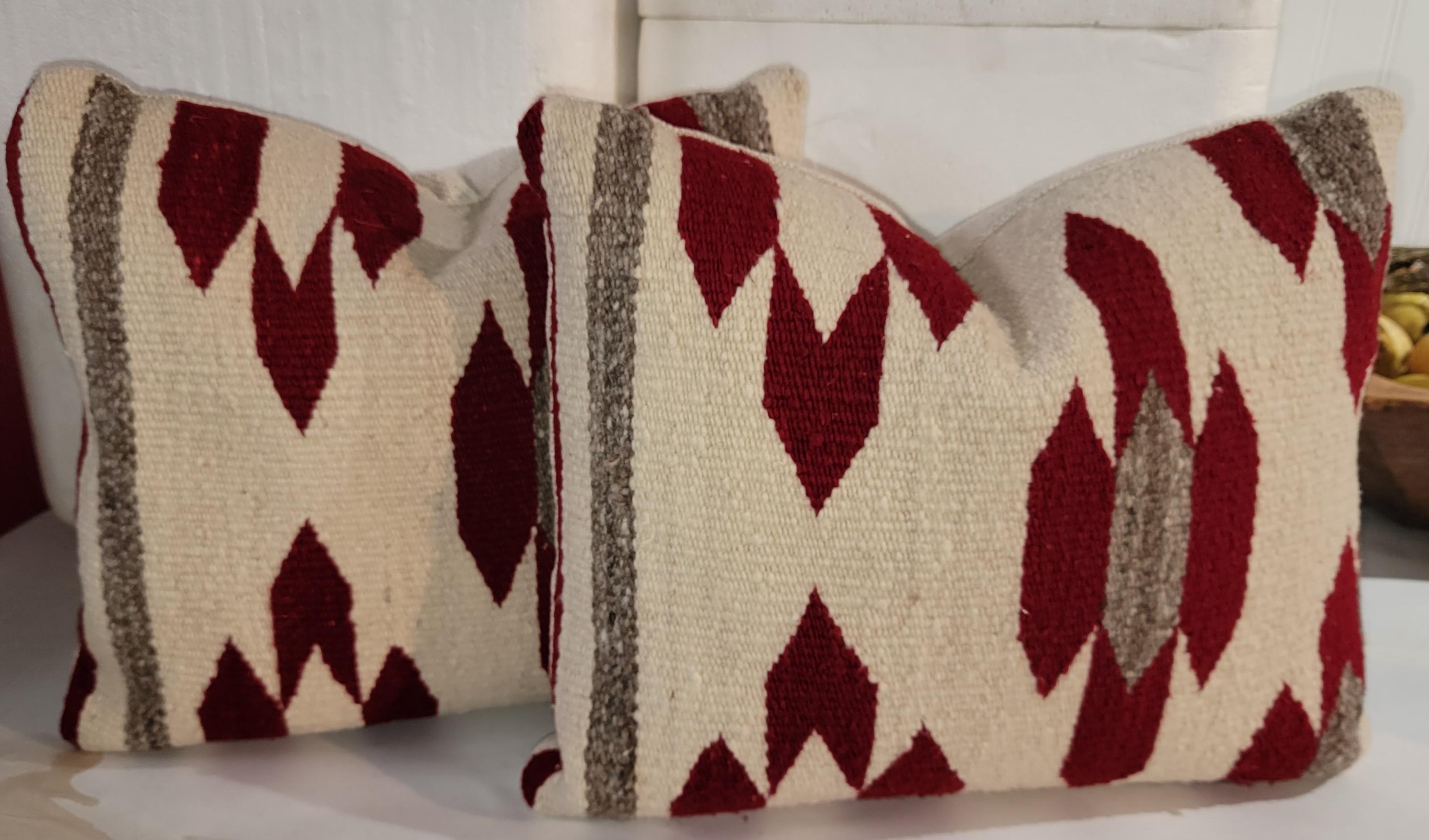 These Navajo Indian saddle blanket weavings were made into pillows with linen backings & down & feather fill.Three pairs that total six pillows. :

White red and brown Chevron design Pillows Measure approx - 16 x 17
Red and white Chevron pillows