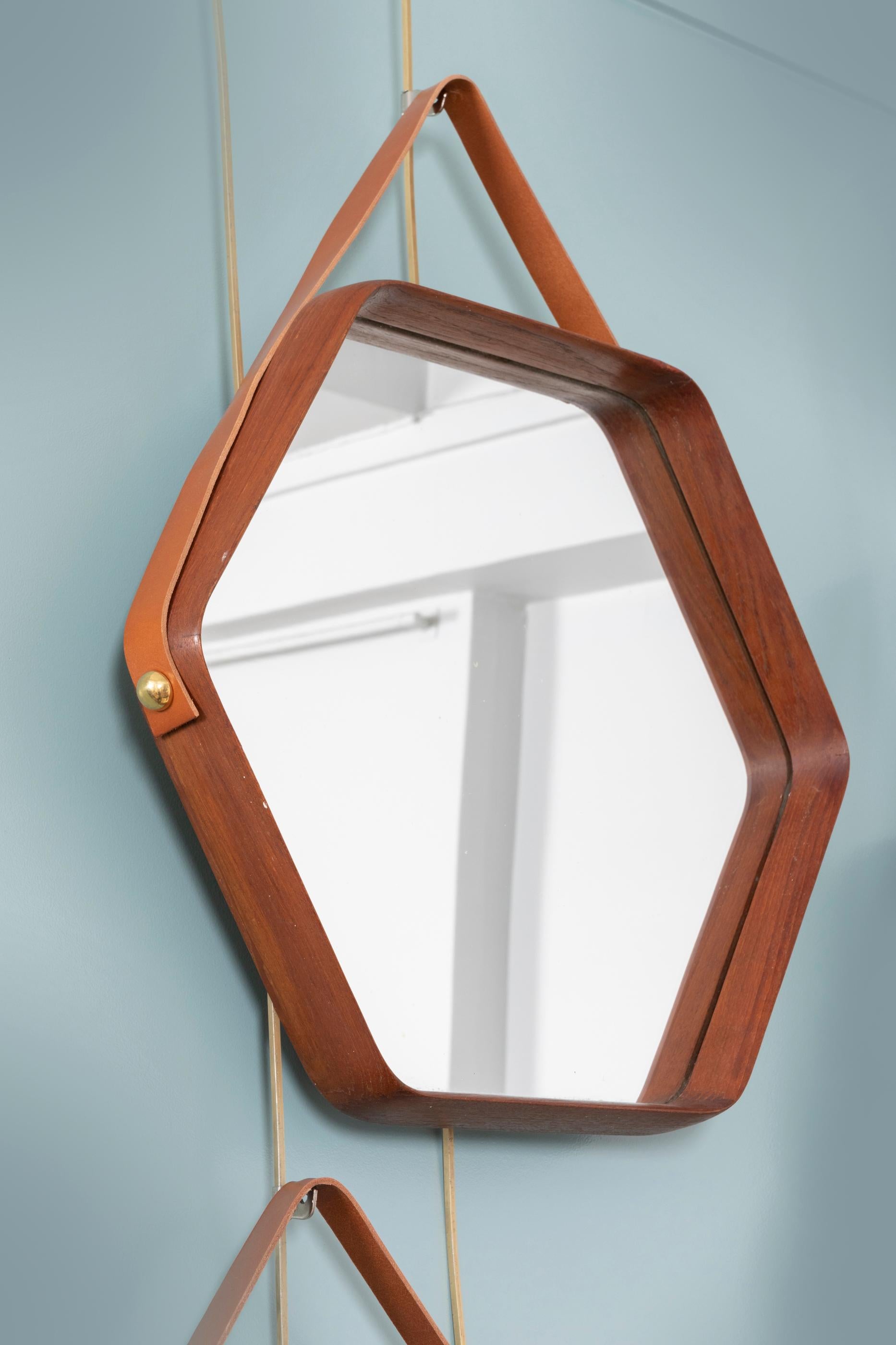 A collection of six elegant wall mirrors.
These mirrors can be displayed in many different combinations to create a stylish wall decoration.
Walnut frames, held with leather straps (replaced). 
Italy, circa 1960. 

Sizes (excluding leather