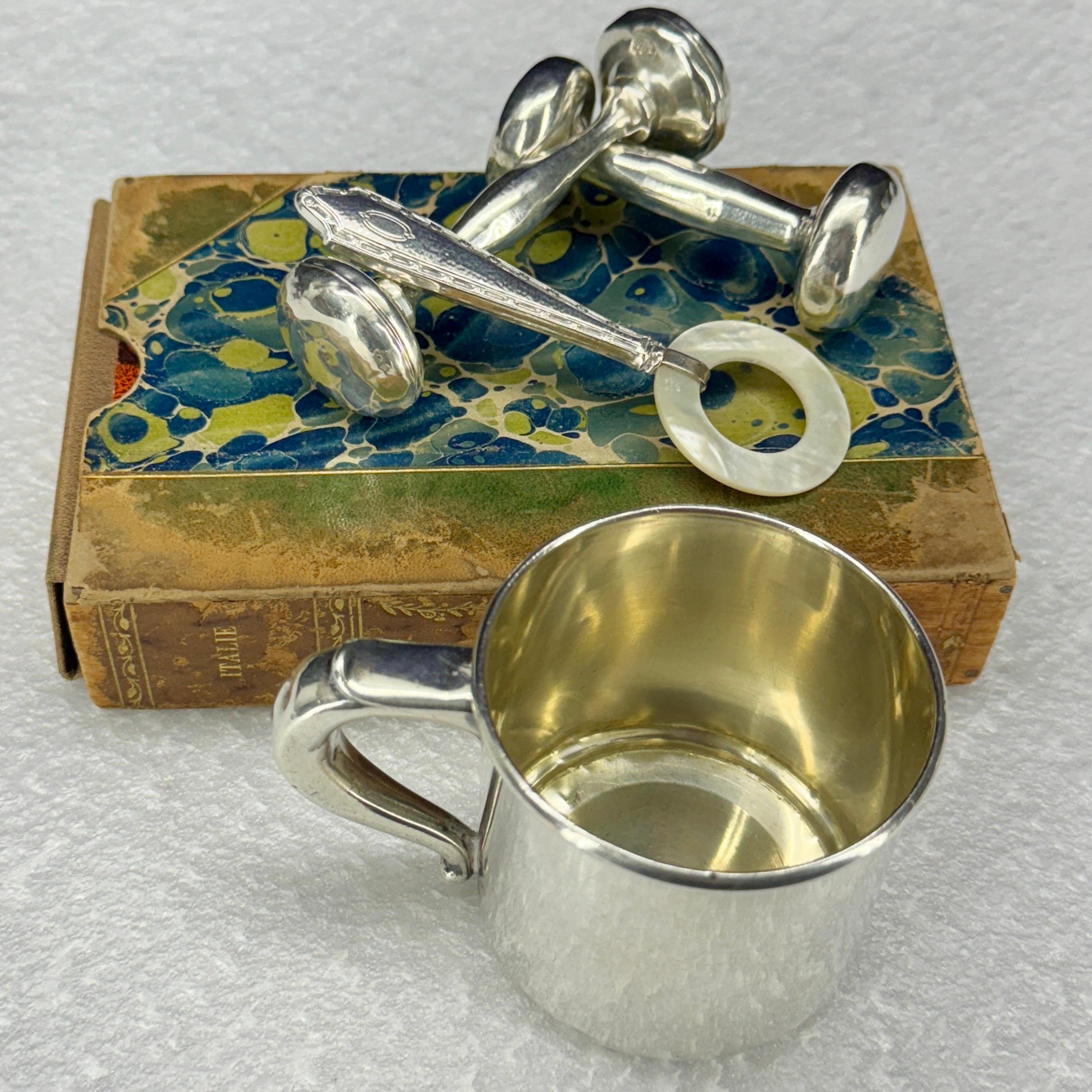 Clásico conjunto de artículos de plata de ley para bebé. Esta colección incluye dos sonajeros para bebé, una taza y un mordedor de nácar. Sin duda, son exquisitos regalos para bebés que perdurarán durante generaciones.

La copa marcada Wallace mide