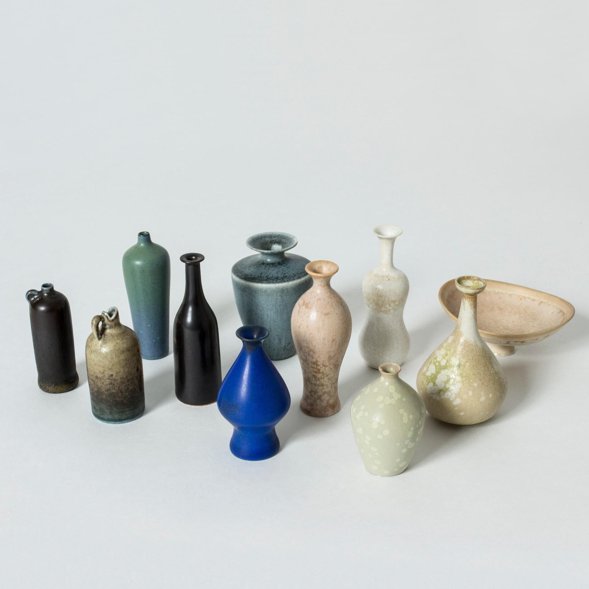 Collection of ten miniature stoneware vases and one bowl by Gunnar Nylund. Exquisite little pieces in different forms. Some are tiny flasks, others imaginative curvaceous vases. Some have pastel colored glaze with “Mimosa” flecks, others have the