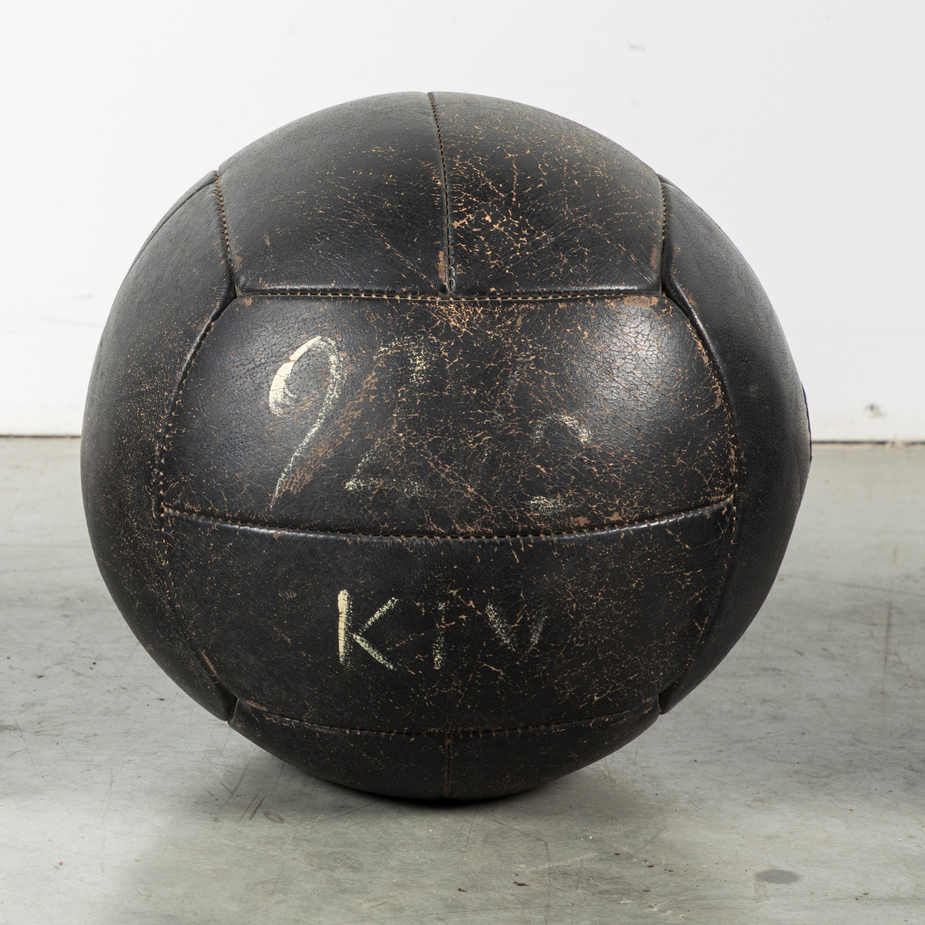 Great vintage collection of three black leather medicine balls. Excellent warm vintage patina. Traces of white painted team letters and numbers.