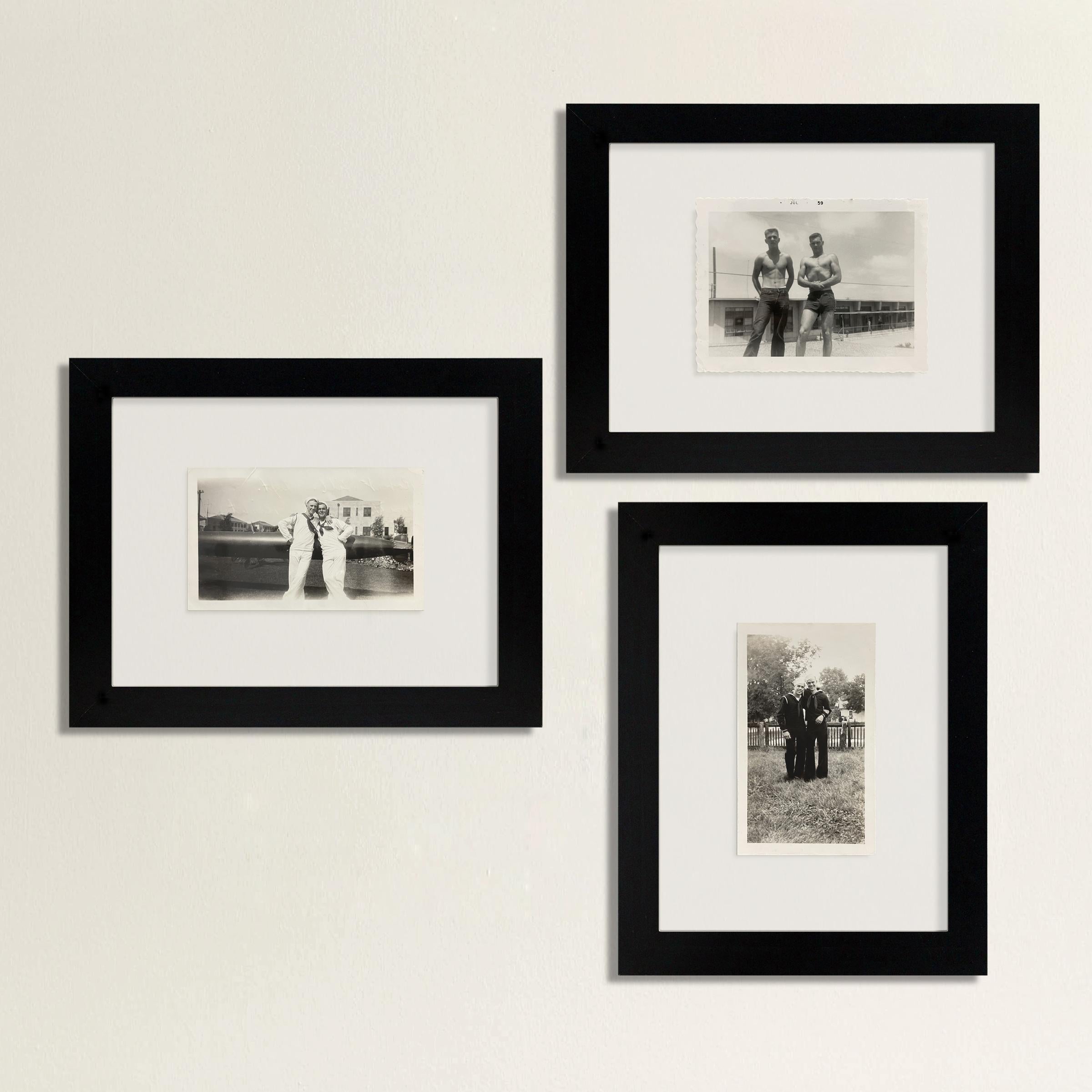 A heartwarming collection of three framed photographs depicting pairs of American soldiers, some in uniform and some flexing their muscles, but all charming and handsome. The photographs are framed with a simple black gallery frame and between two