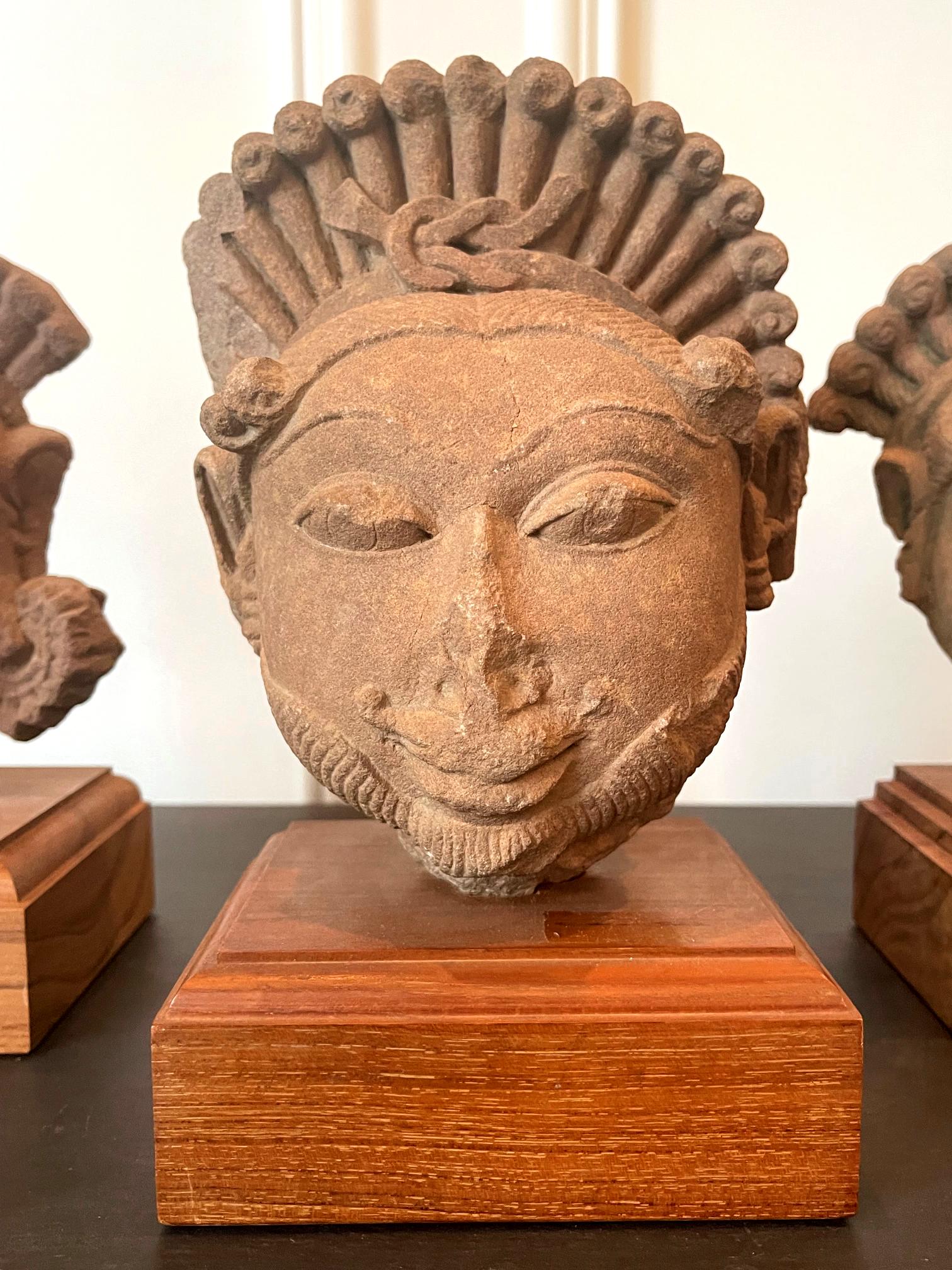 Collection de trois têtes de divinités indiennes sculptées dans le grès en vente 1