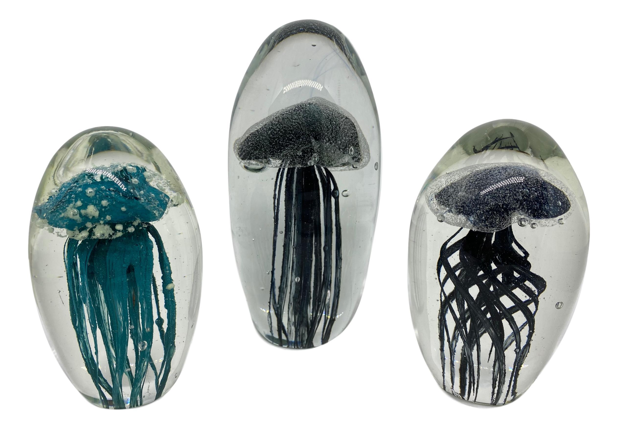 Beautiful set of three Murano hand blown aquarium design Italian art glass paper weights. Showing jelly fish inside, in two different colors, floating on controlled bubbles. Colors are a black and turquoise; cyan. Tallest measure: 5 3/4