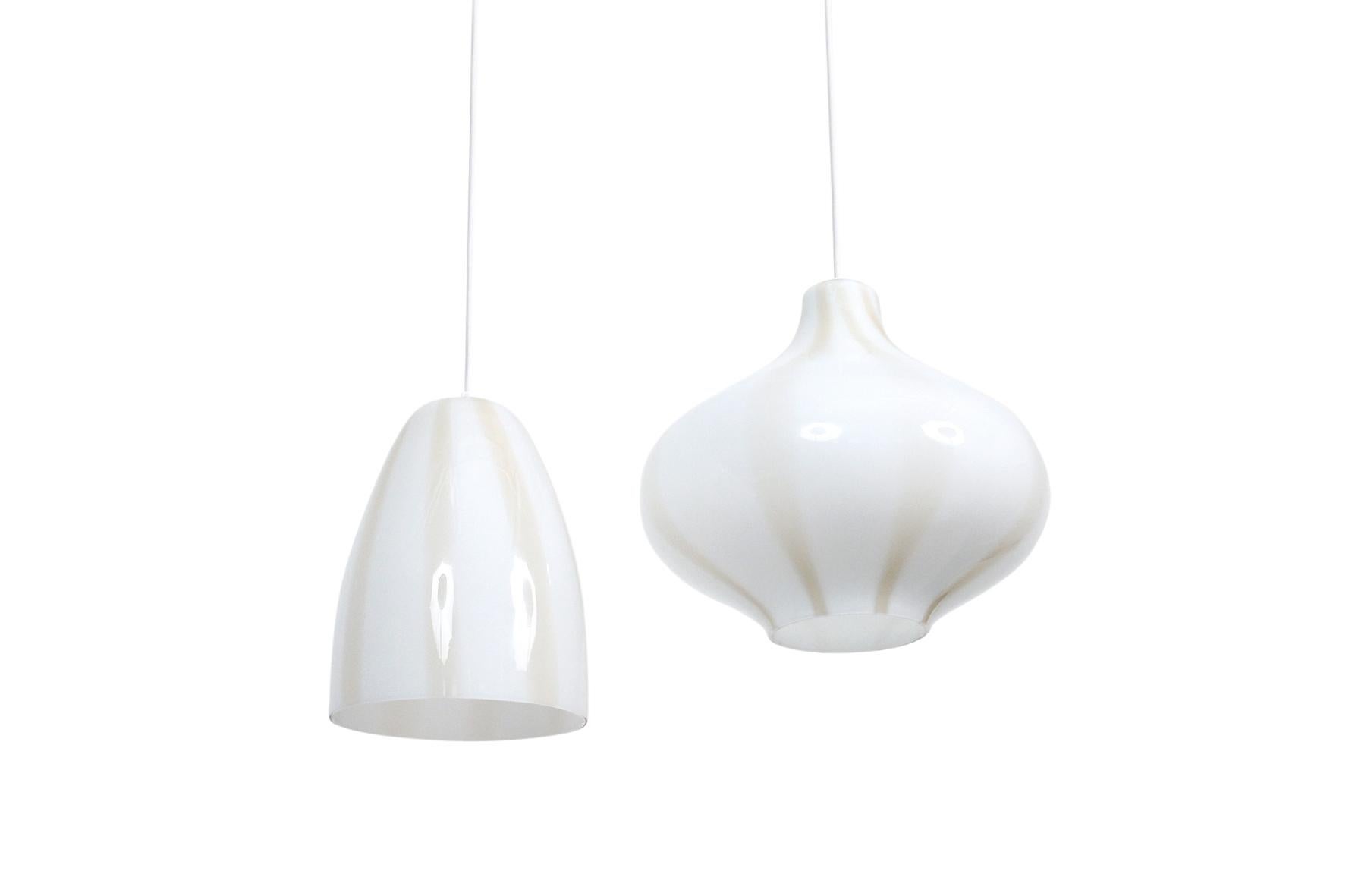 Collection of three pendants by Paolo Venini for the famed Italian glass company. These pendants are executed in a white case glass with subtle bronze striping. Hung along a straight line or in a circular configuration they would create a large