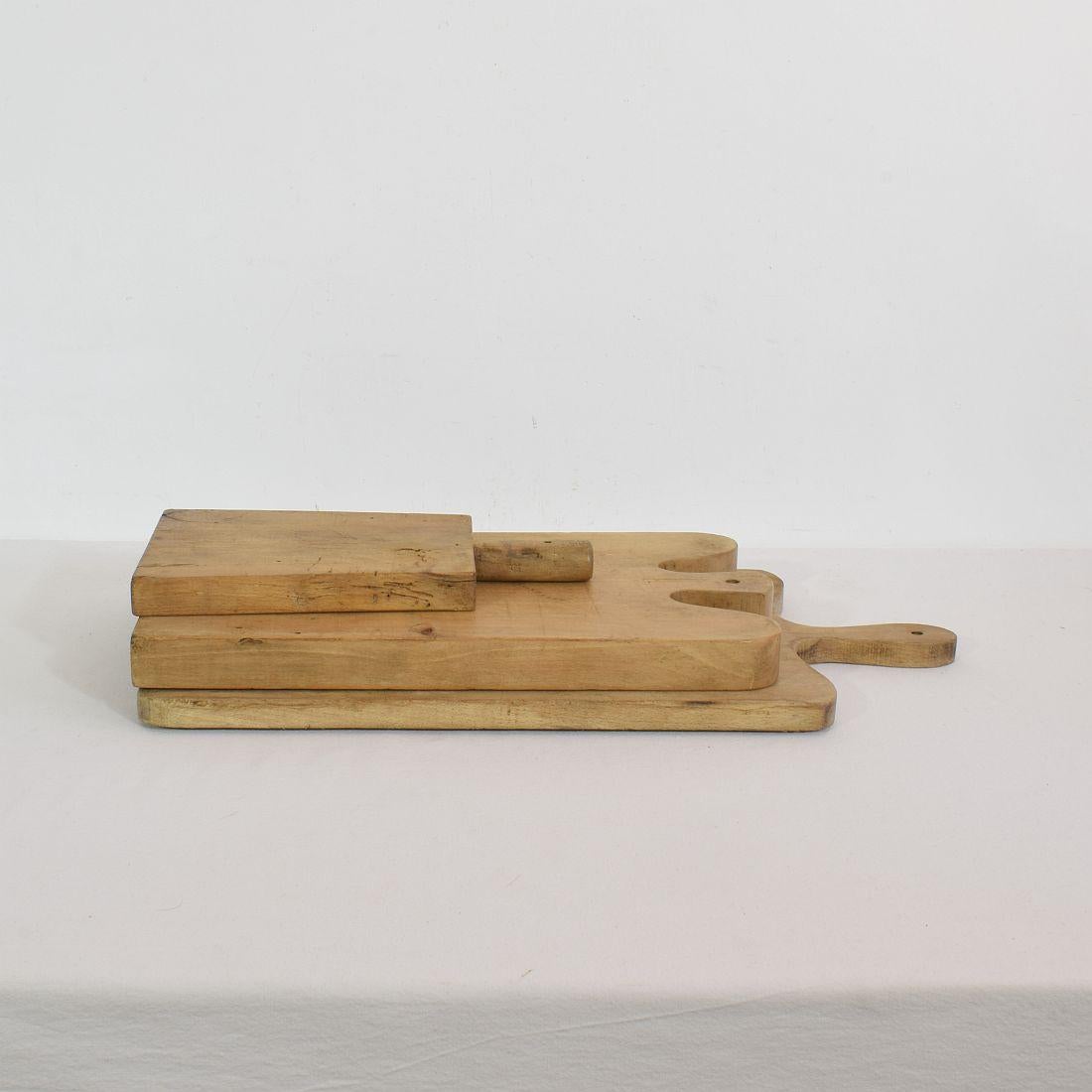Beautiful small collection of three wooden chopping-cutting boards. Great statement on your counter-top,
France, circa 1850-1900. Weathered. Measures: H:29-53cm W:16-27cm D:1,5-3cm. Measurement here below of the largest cutting board. More pictures