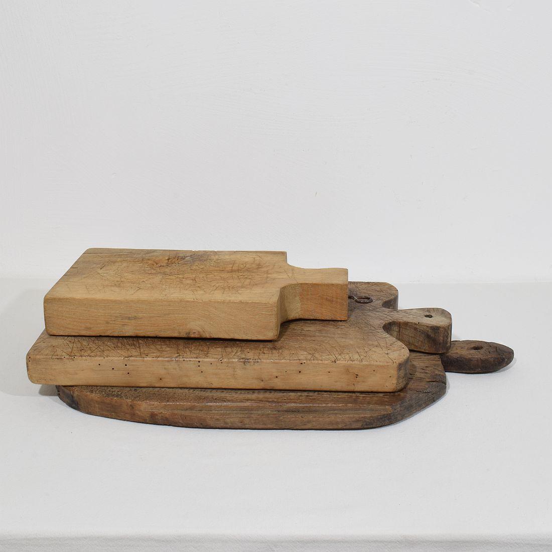 Beautiful  collection of three wooden chopping-cutting boards. Great statement on your counter-top,
France, circa 1850-1900. Weathered. Measures:H:36-56,5cm  W:20,5-34cm D:2,5-5cm  . Measurement here below of the largest cutting board. More pictures