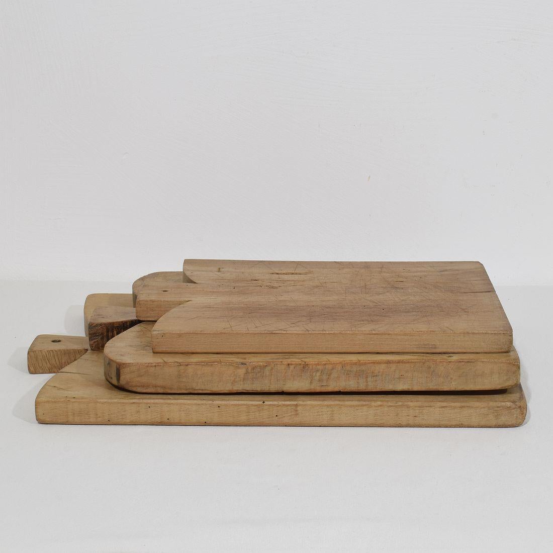 Beautiful  collection of three wooden chopping-cutting boards. Great statement on your counter-top,
France, circa 1850-1900. Weathered. Measures: H:39-52,5cm  W:25-32cm D:2,5-3cm  . Measurement here below of the largest cutting board. More pictures