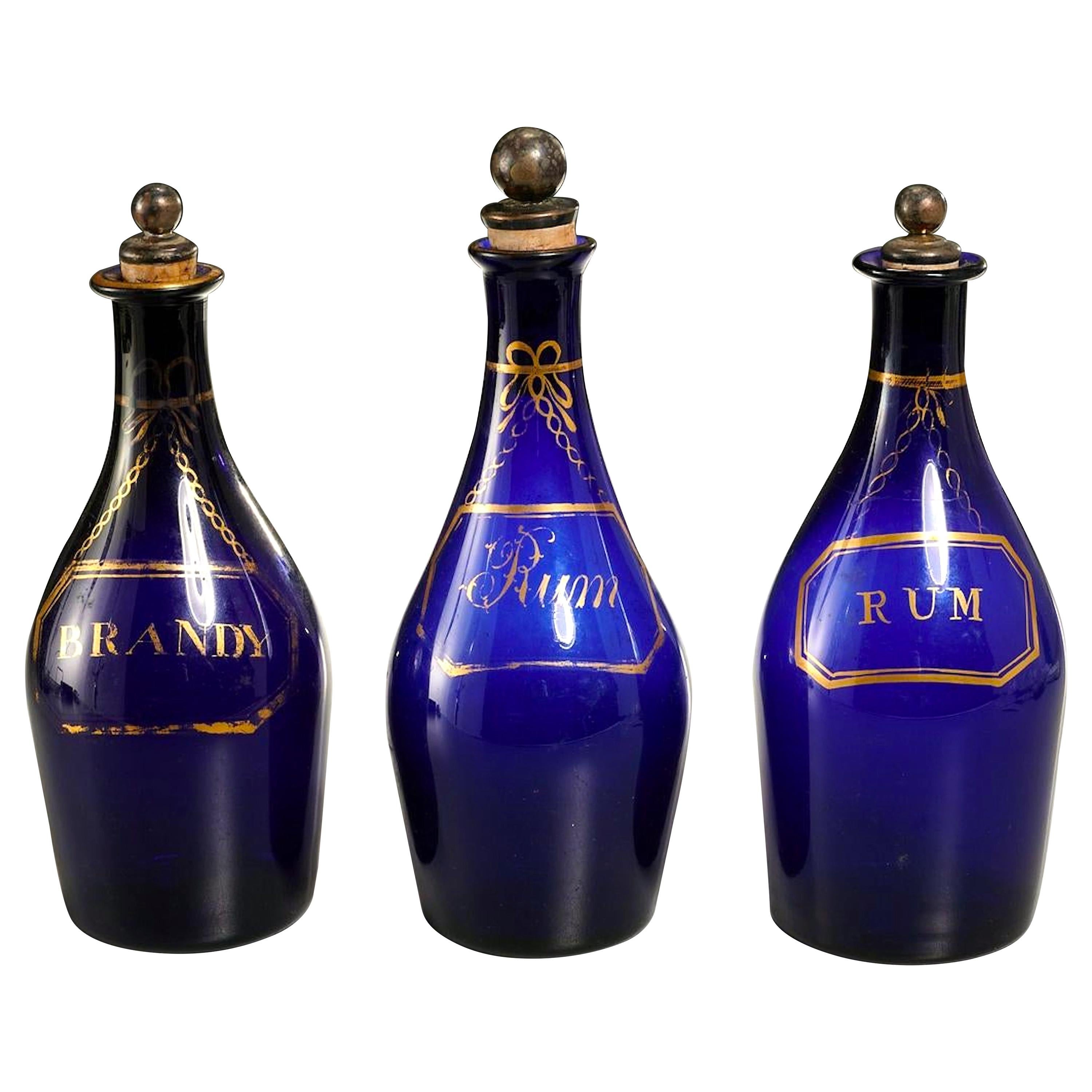 Collection de trois bouteilles de Rum et Brandy bleu cobalt précoce en vente