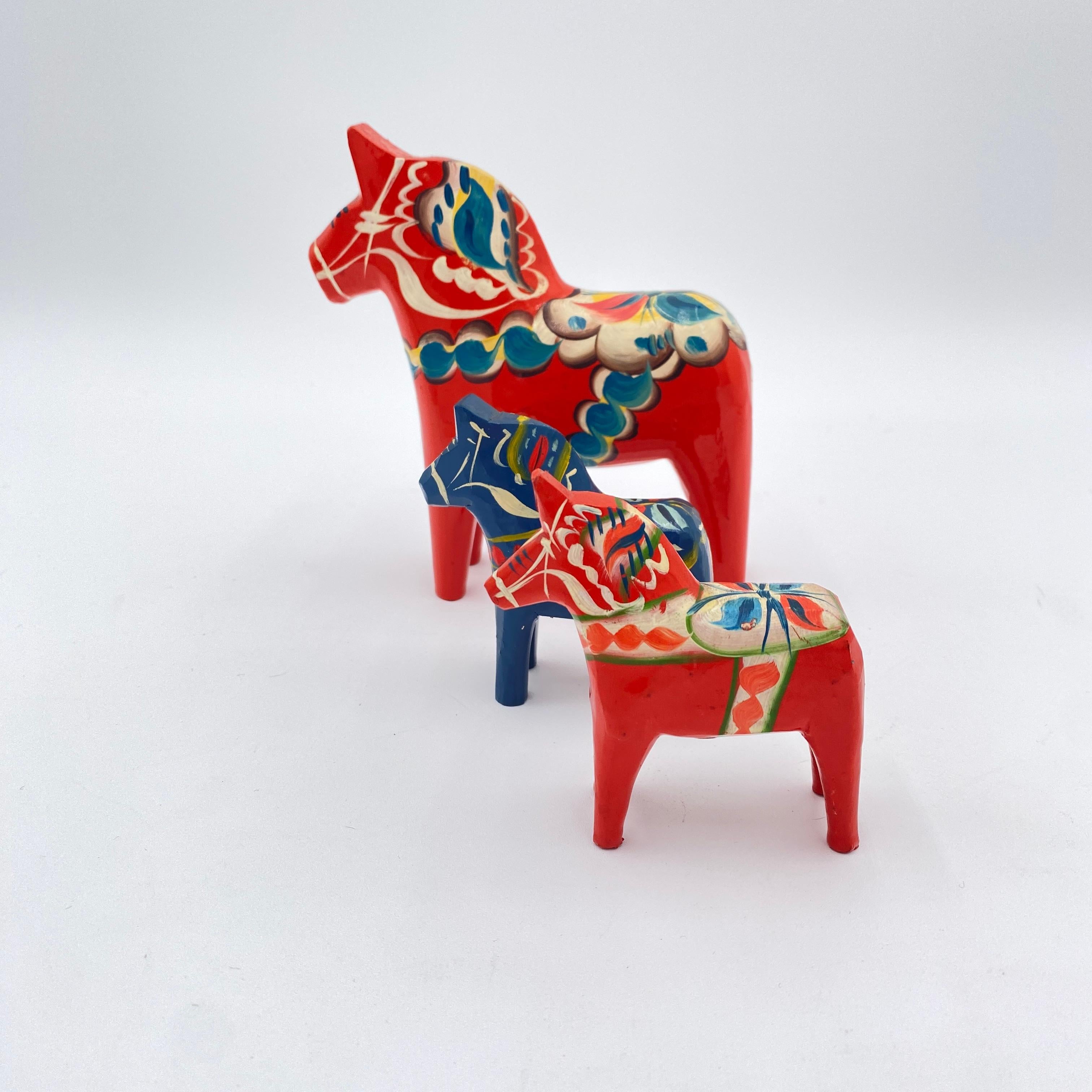 This is a collection of three Swedish Dala Horses by Nils Olsson. These are hand-carved and hand-painted wood. The larger one is approximately 5