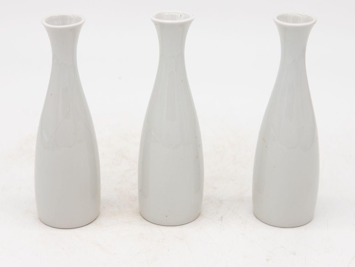 Chaque vase en céramique blanche, fabriqué en France au début du 21e siècle, fait partie d'un ensemble de trois, plusieurs ensembles étant disponibles pour les collectionneurs. Chaque vase est élégamment estampillé 