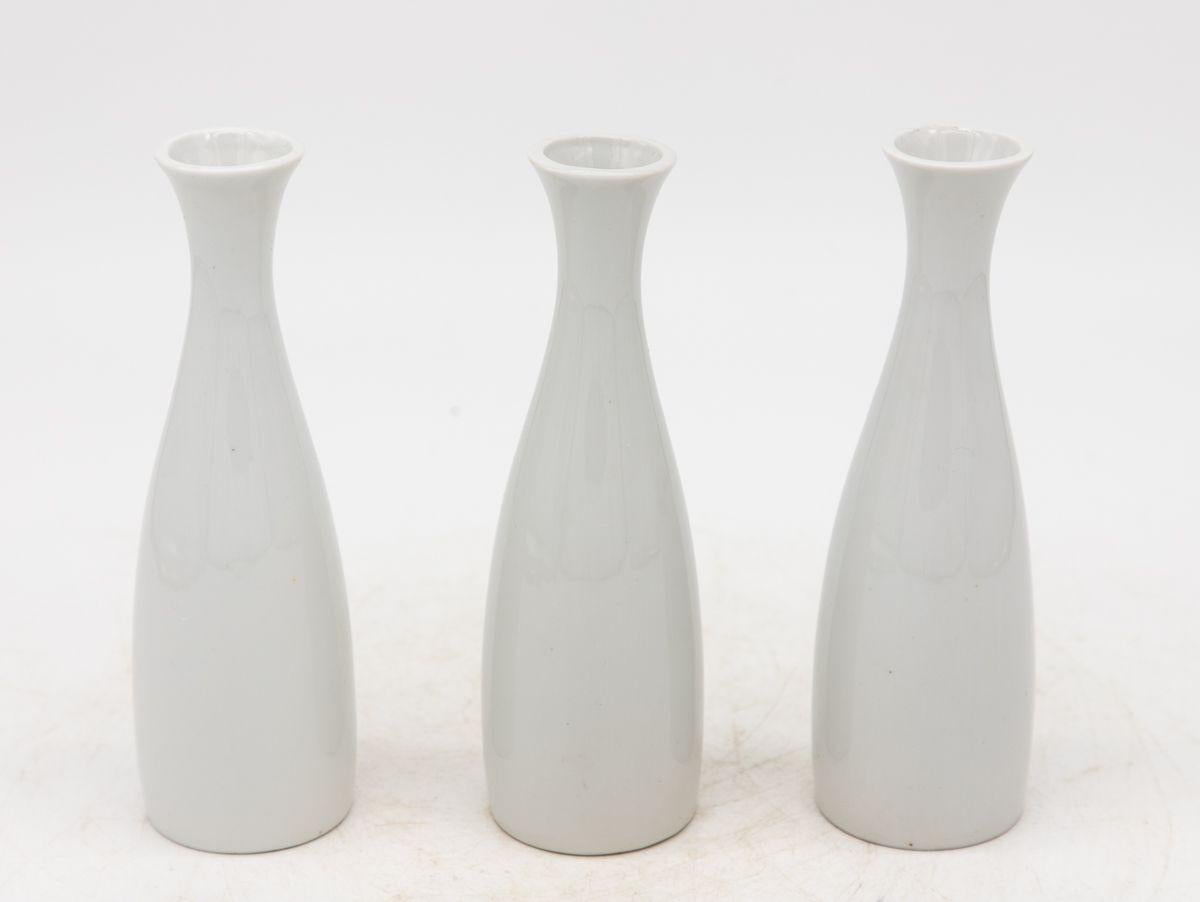 Chaque vase en céramique blanche, fabriqué en France au début du 21e siècle, fait partie d'un ensemble de trois, plusieurs ensembles étant disponibles pour les collectionneurs. Chaque vase est élégamment estampillé 