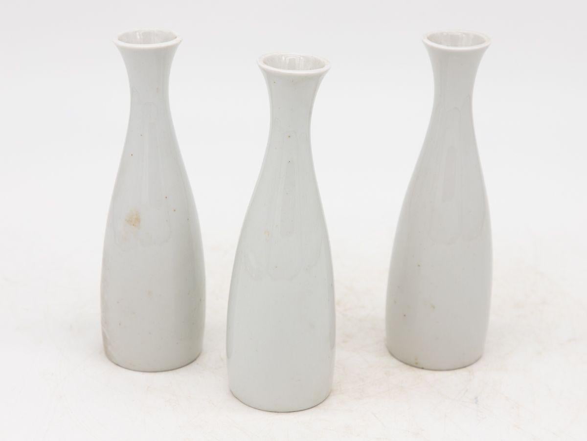 Chaque vase en céramique blanche, fabriqué en France au début du 21e siècle, fait partie d'un ensemble de trois, plusieurs ensembles étant disponibles pour les collectionneurs. Chaque vase est élégamment estampillé 