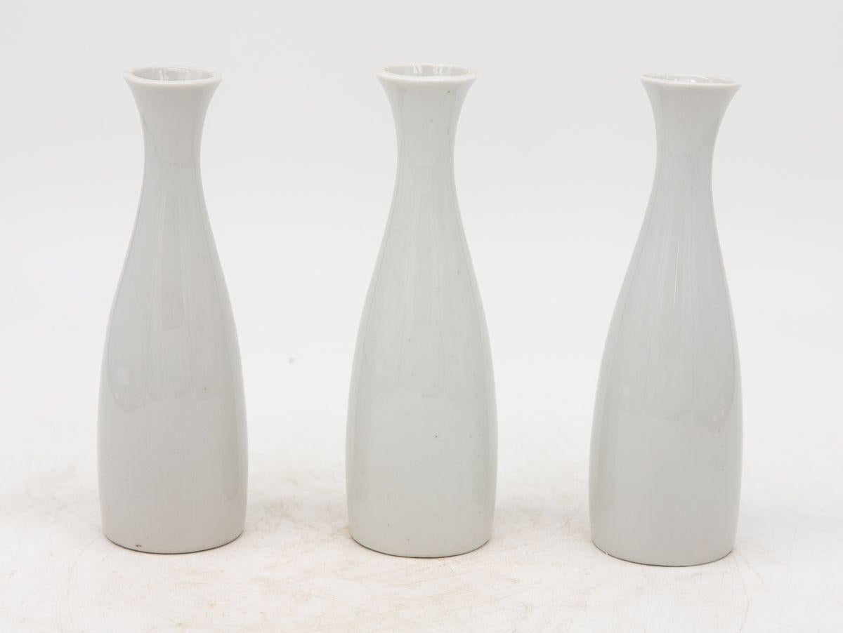 Each single white ceramic vase, crafted in early 21st century France, is part of a set of three, with multiple sets available for collectors. Each vase is elegantly stamped with 