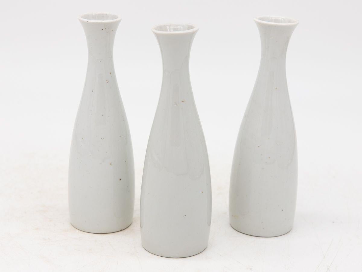 Chaque vase en céramique blanche, fabriqué en France au début du 21e siècle, fait partie d'un ensemble de trois, plusieurs ensembles étant disponibles pour les collectionneurs. Chaque vase est élégamment estampillé 