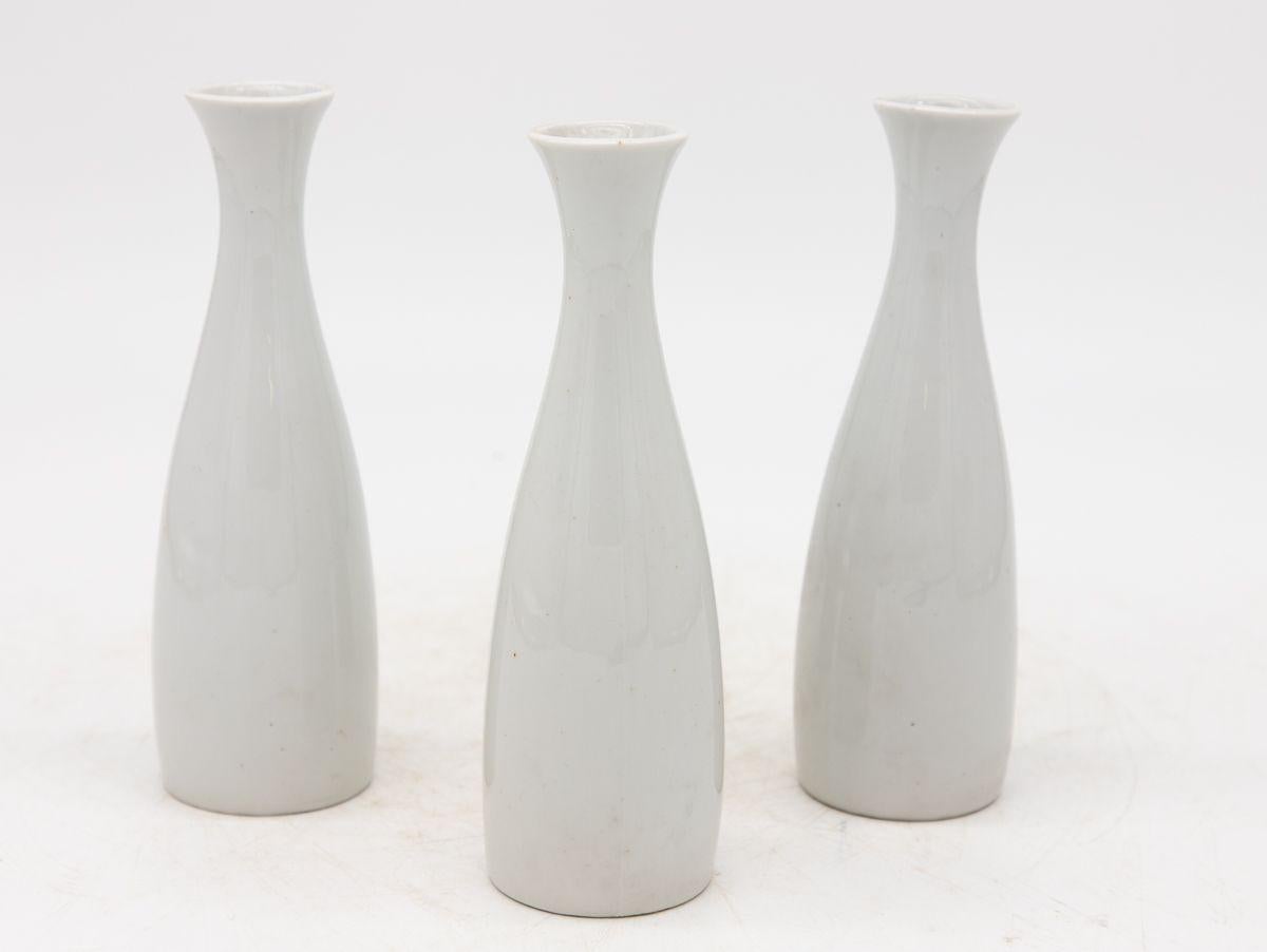 Each single white ceramic vase, crafted in early 21st century France, is part of a set of three, with multiple sets available for collectors. Each vase is elegantly stamped with 