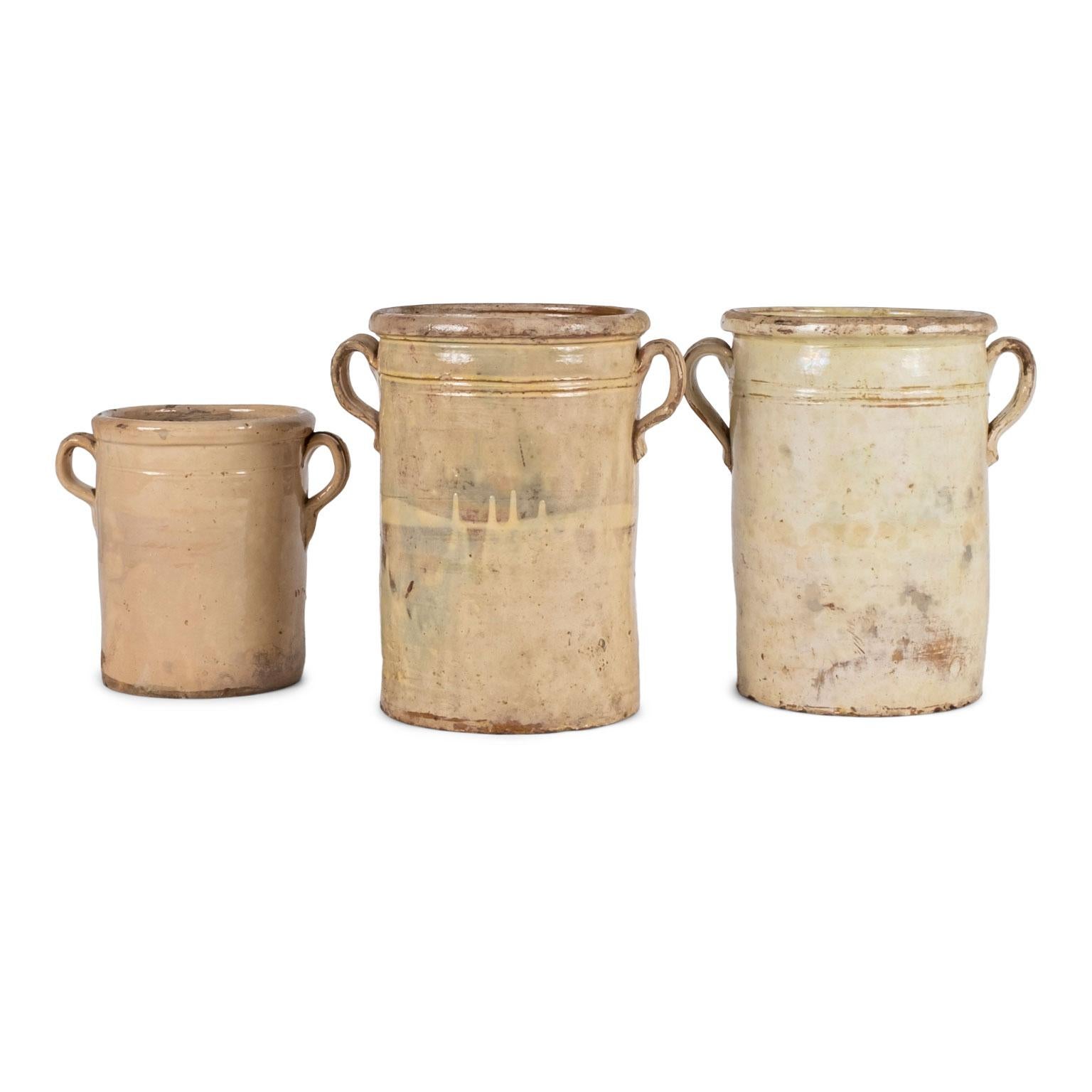 Collection of three yellow glazed jars, (19th century, France).

Sizes from L to R in the second image:
9.75 inches high x 10.5 inches wide x 7.75 inches deep
13.75 inches high x 12 inches wide x 9.75 inches deep
13.5 inches high x 12.5 inches