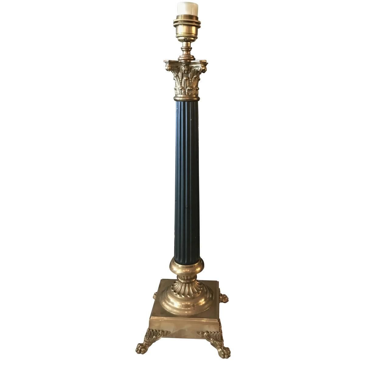 Pair of Empire-style table lamps hail from the private collection of American fashion designer Tommy Hilfiger. Both have fluted column posts with brass fittings and brass bases with claw feet. Ideal for a traditional living room décor. Sold in a set