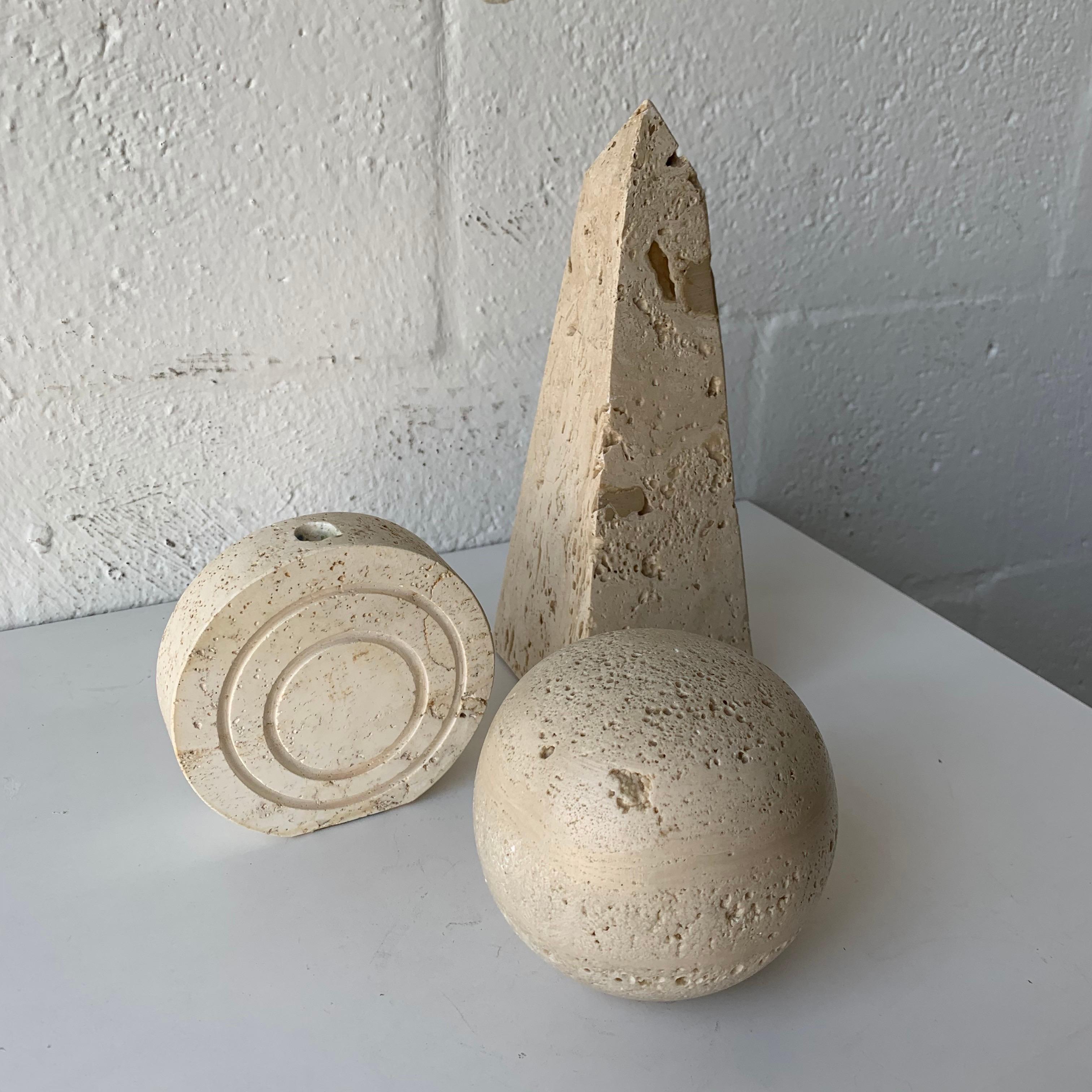 Collection of objects consisting of an obelisk, sphere, and disk or puck bud vase, rendered in travertine designed by F. Lli Mannelli for Raymor, Italy, 1960s.