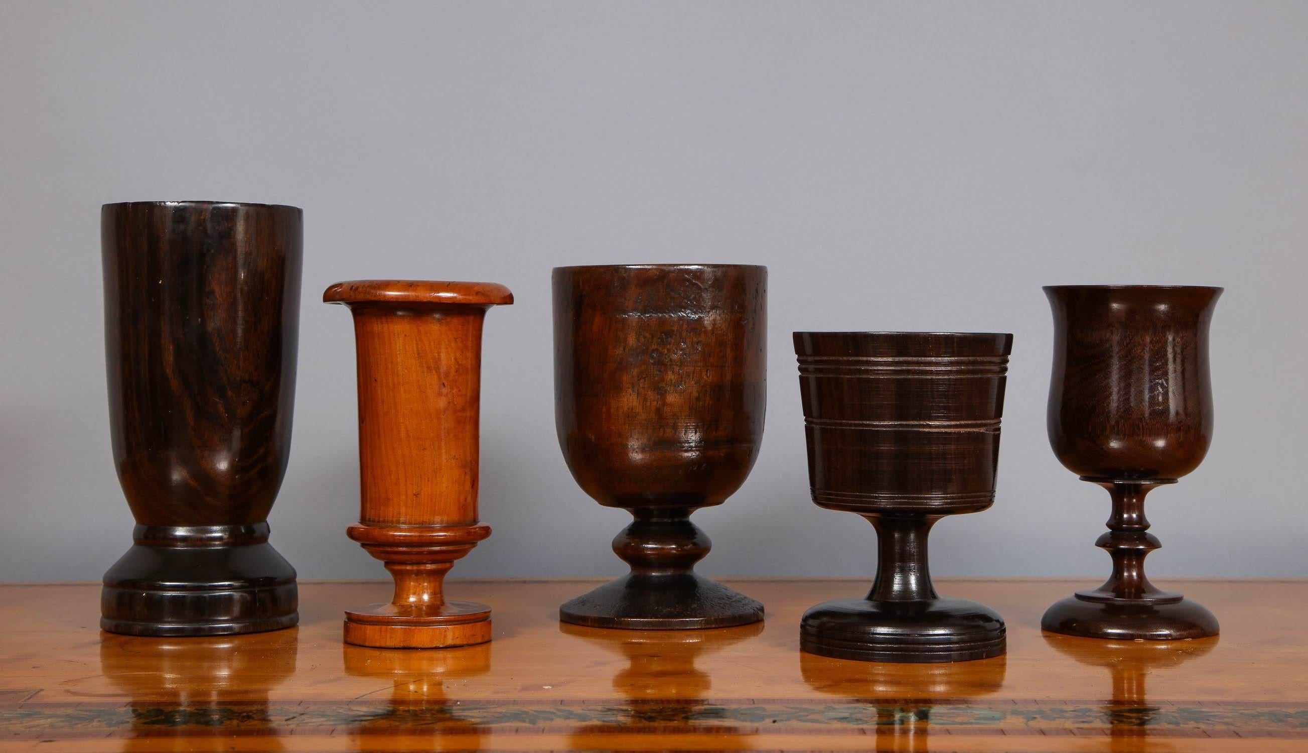 Fine assortment of English 18th and 19th century turned wooden vessels comprising, from left to right, an 18th century turned Lignum Vitae vase ($750), a fine early 19th century turned pearwood spill vase, ex collection of A. J. Levi ($1,650), an
