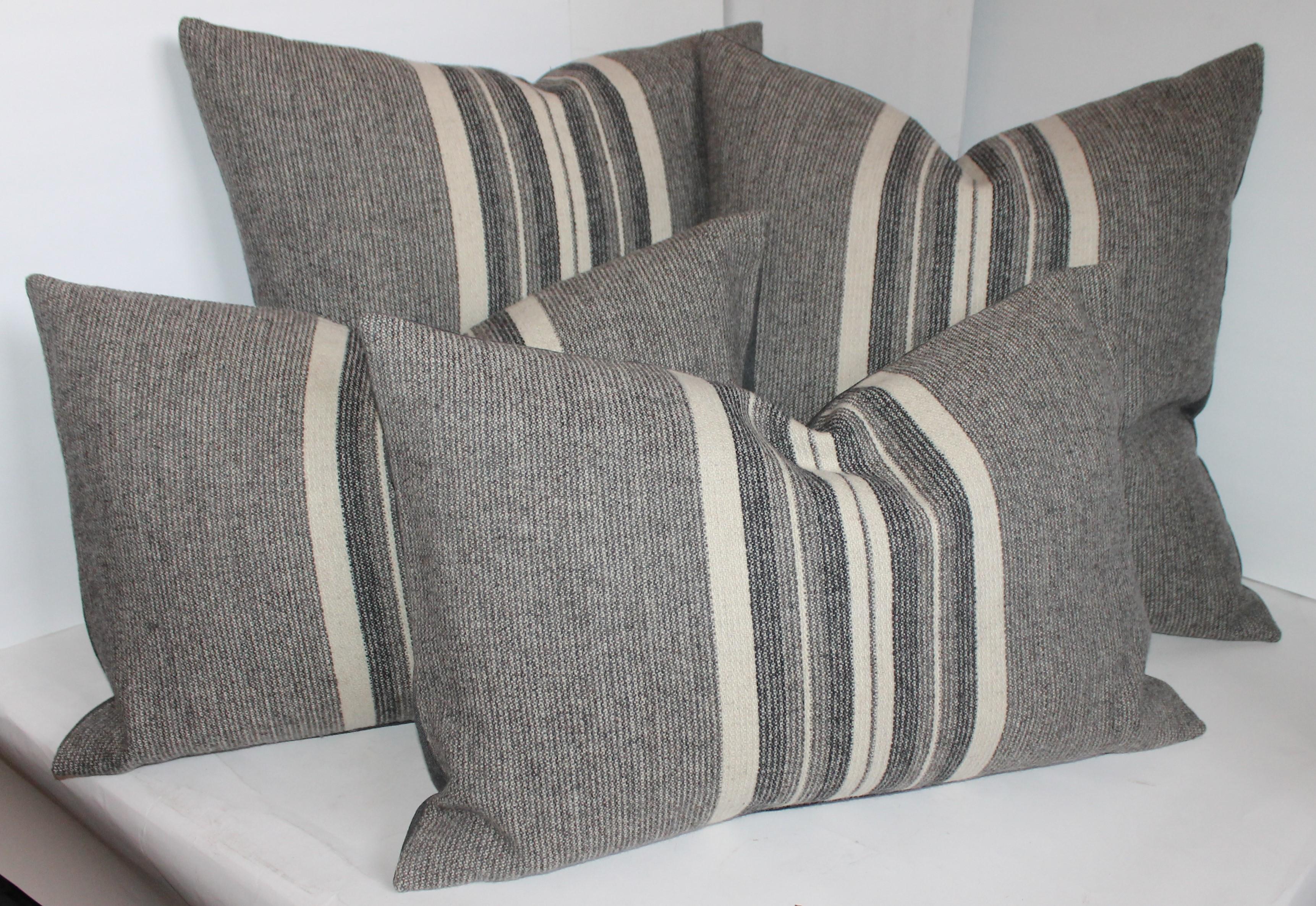 Collection of two different size pillows in grey flannel wool woven fabric. The backings are in grey cotton linen.
The larger pair are 22 x 22 and the kidney pillows are 15 x 24. Sold as a group. All in fine condition and down and feather fill.