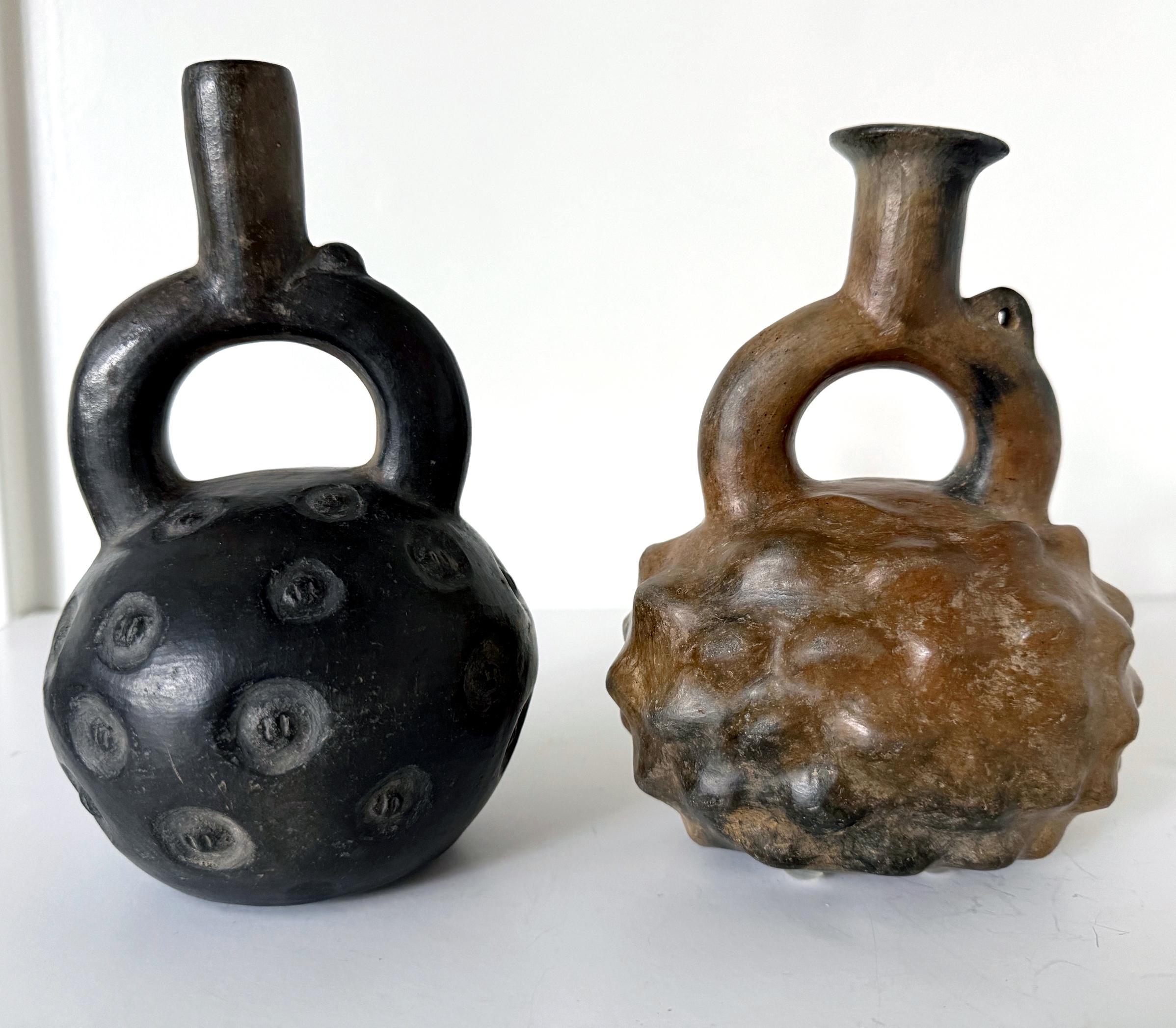 Una collezione di due piccoli vasi a staffa in ceramica Pre-Columbian in stile Cupisnique del 700-500 a.C. circa. Questi antichi vasi del periodo formativo si distinguono per la loro forma robusta con un caratteristico e spesso germoglio a staffa.