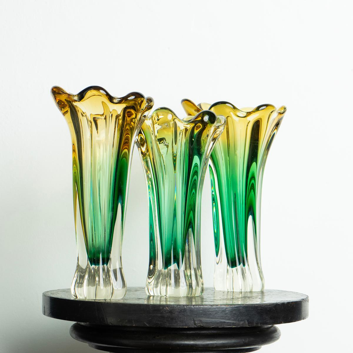 Mid-century hand-blown glass vase collection
A collection of three graduated vases of twisted naturalistic forms in green, yellow and clear glass.

Dating from the 1960s-1970s period.

They are all in very good vintage condition with only minor