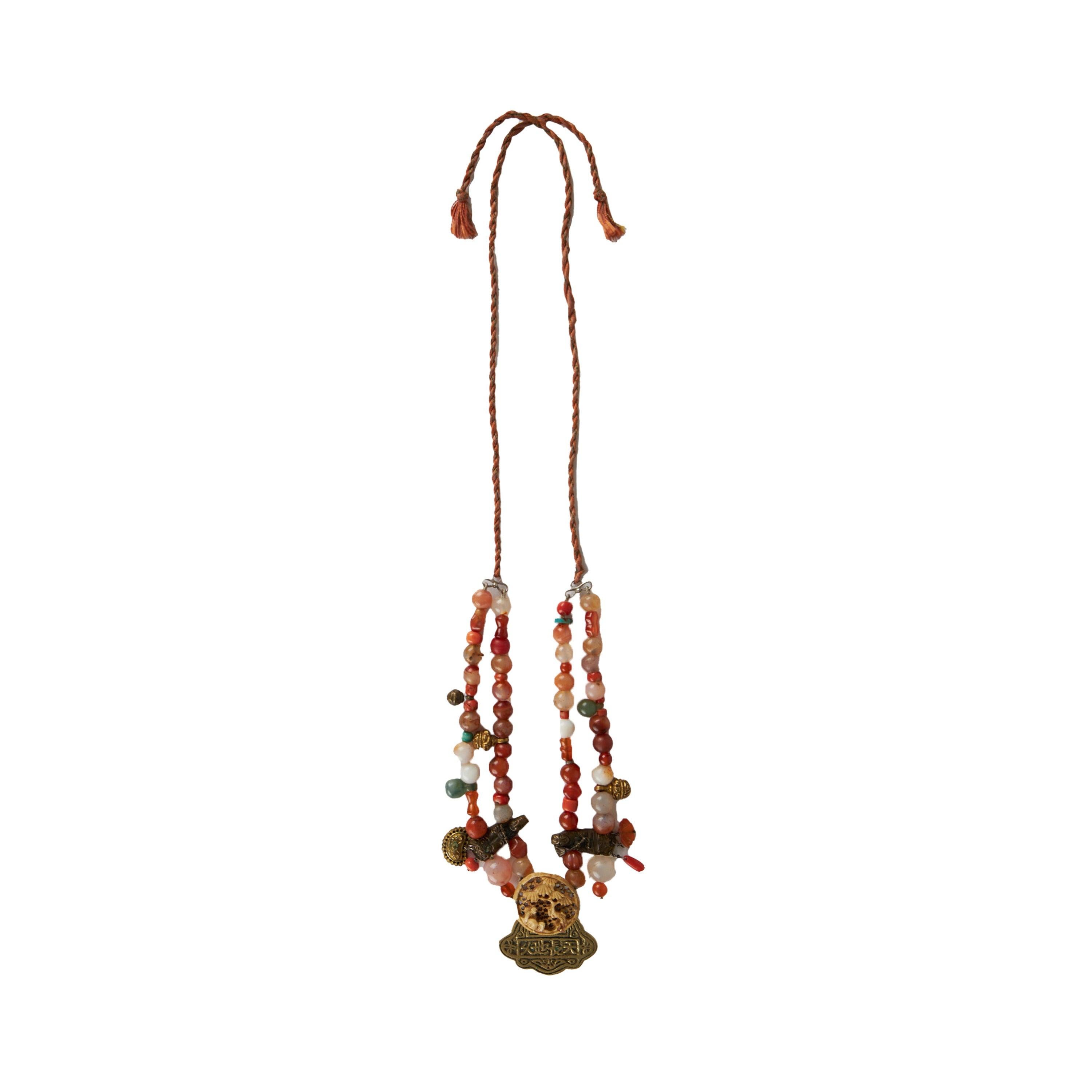 Questa collana antica di Collection Privée è realizzata con pietre multicolori e plexiglass, metallo antico scolpito e una figura di albero incisa. Questo pezzo forte può essere indossato come collana o girocollo grazie al cordoncino regolabile. 
