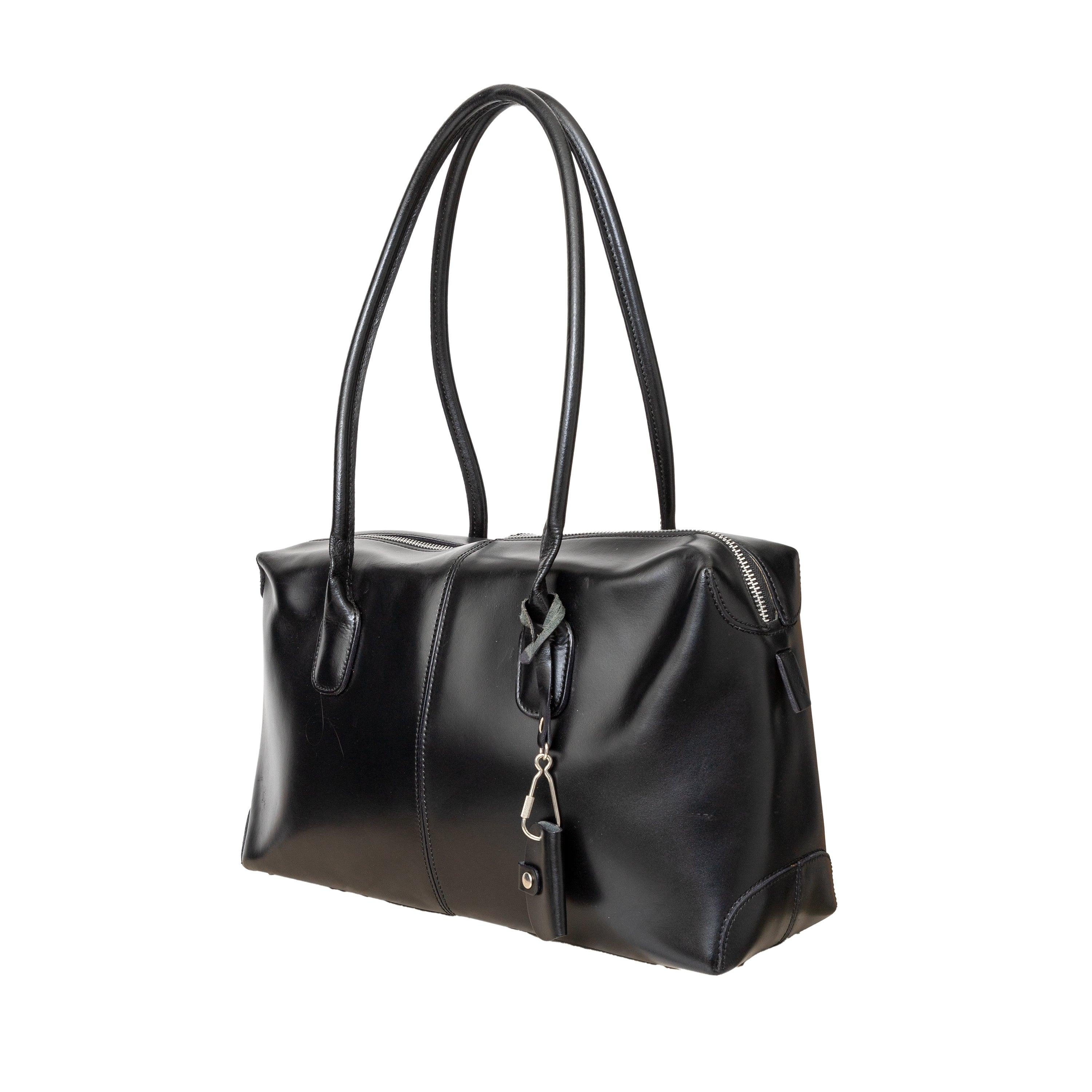 Le sac Collectional S est un sac à bandoulière élégant et compact en cuir noir brillant. Il est doté d'un compartiment principal zippé sur le dessus pour un accès facile, de deux poignées roulées pour un transport confortable et d'une pochette avec