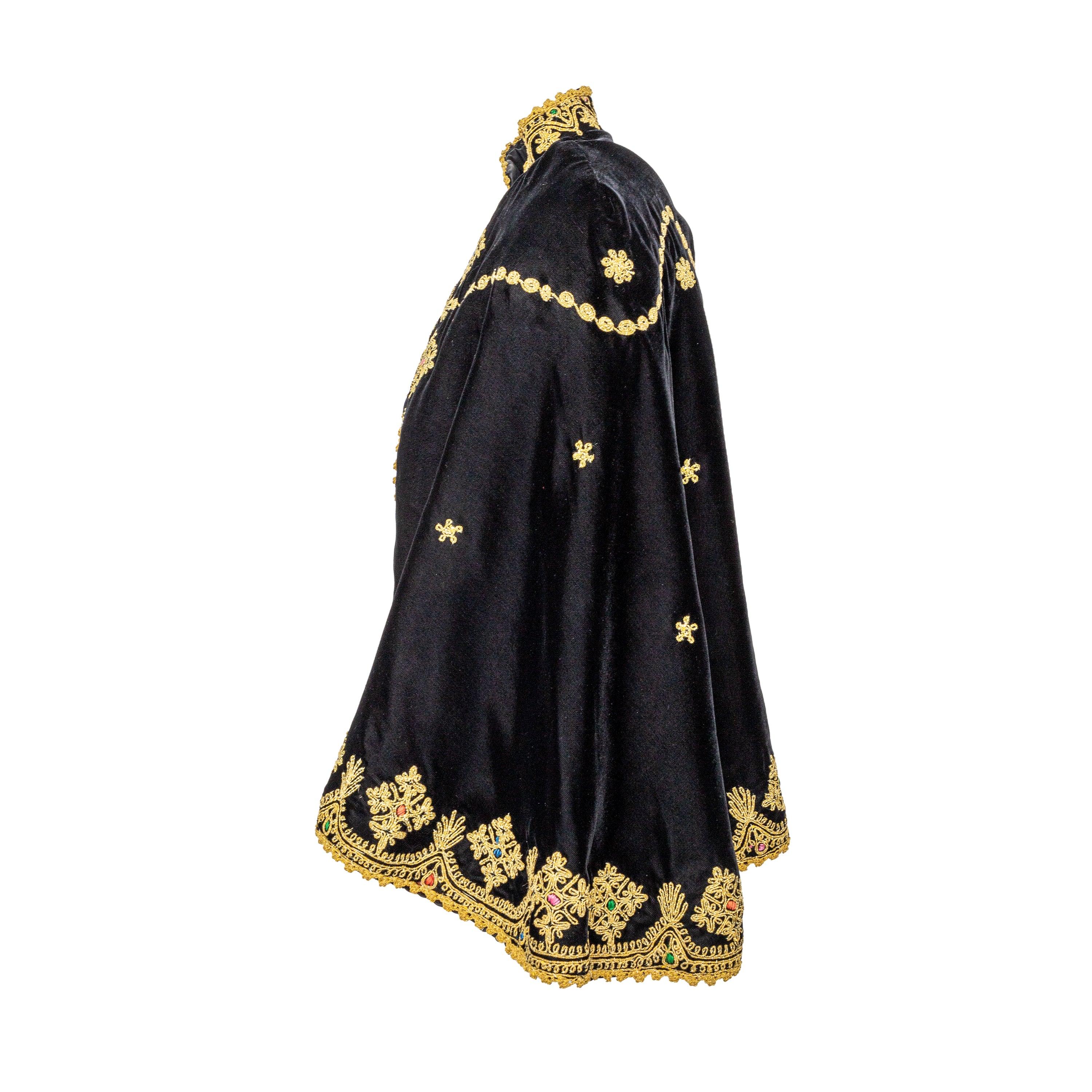Questo poncho vintage fatto a mano degli anni '60 è un pezzo tradizionale da cerimonia proveniente da una collezione privata. Il lussuoso tessuto di velluto è ornato da intricati ricami dorati e multicolori, che gli conferiscono uno stile vittoriano