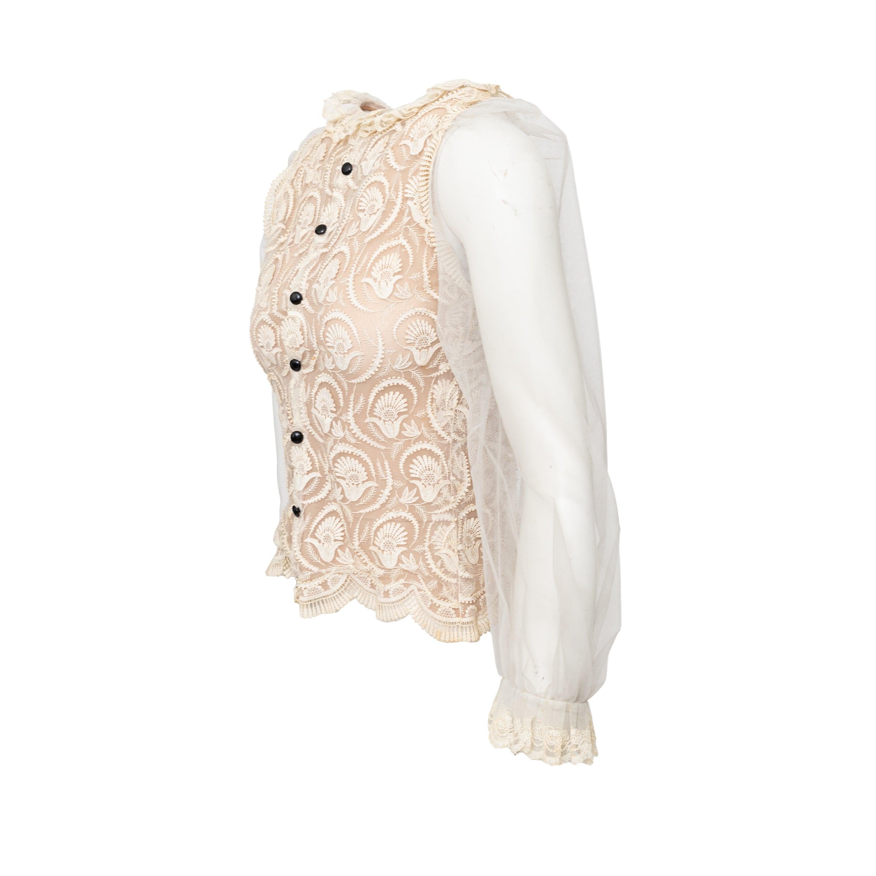 Eleva il tuo guardaroba con il nostro top in pizzo Collection'S. Realizzato in lussuosa rete beige e delicato tessuto di pizzo, questo top presenta un colletto corto a girocollo ed è ornato da affascinanti dettagli a volant, mentre le maniche a