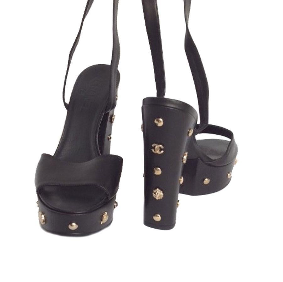 Collector! Chanel platform sandals in black box leather and gold metal. Size 39.5.
Those shoes are set with nails of various shapes including the 'double C' and the camellia as emblematic motifs of the brand. The front of the shoe is connected to