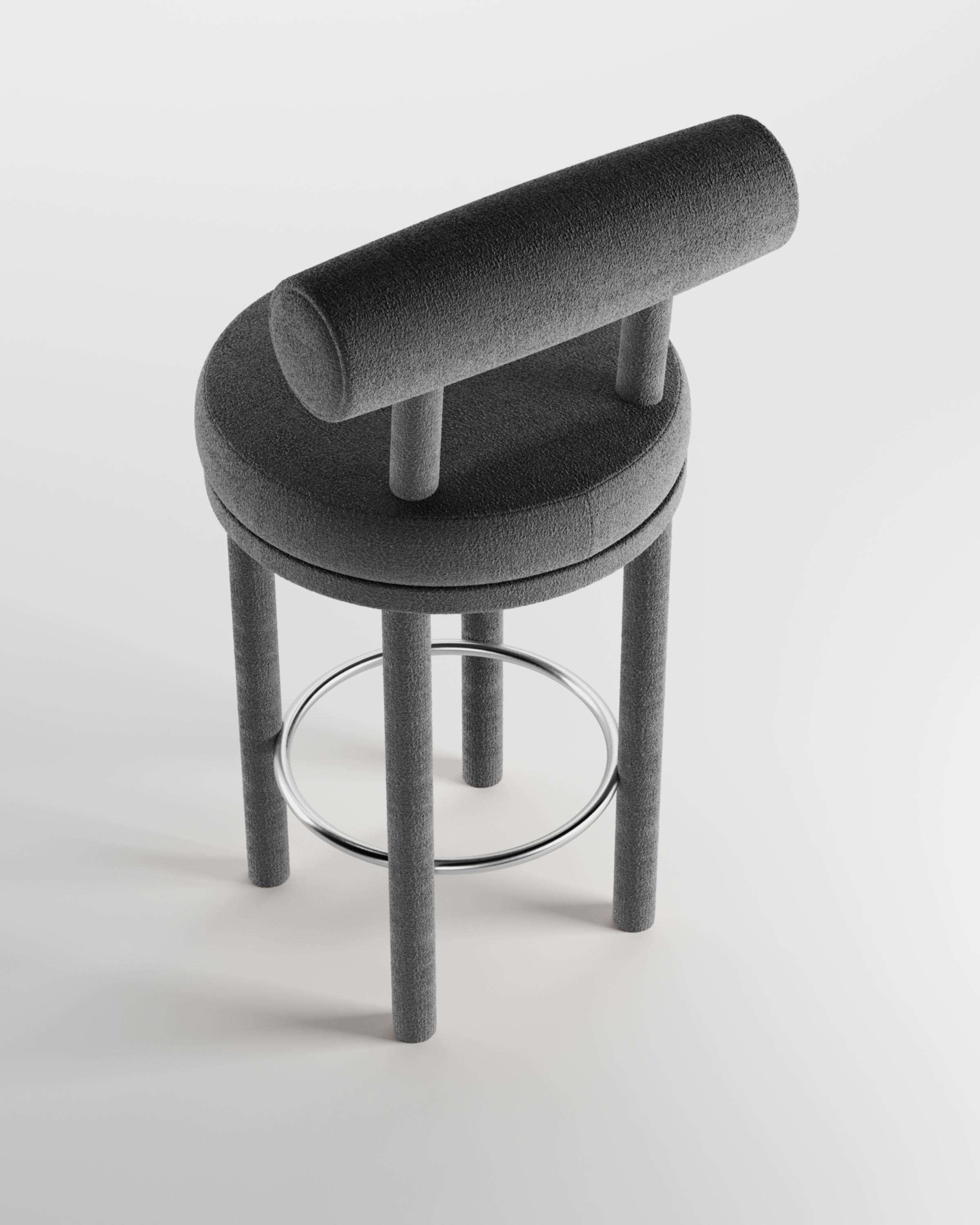 Moderner Moca Barstuhl mit Stoffbezug von Studio Rig für Collector Studio

Ein Stuhl, der sowohl moderne als auch klassische Designansätze miteinander verbindet.
Der strapazierfähige und solide Stuhl ist so konzipiert, dass er sich an den Körper