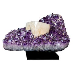 Gruppo di ametiste da collezione con una grande calcite tabulare pseudocubica