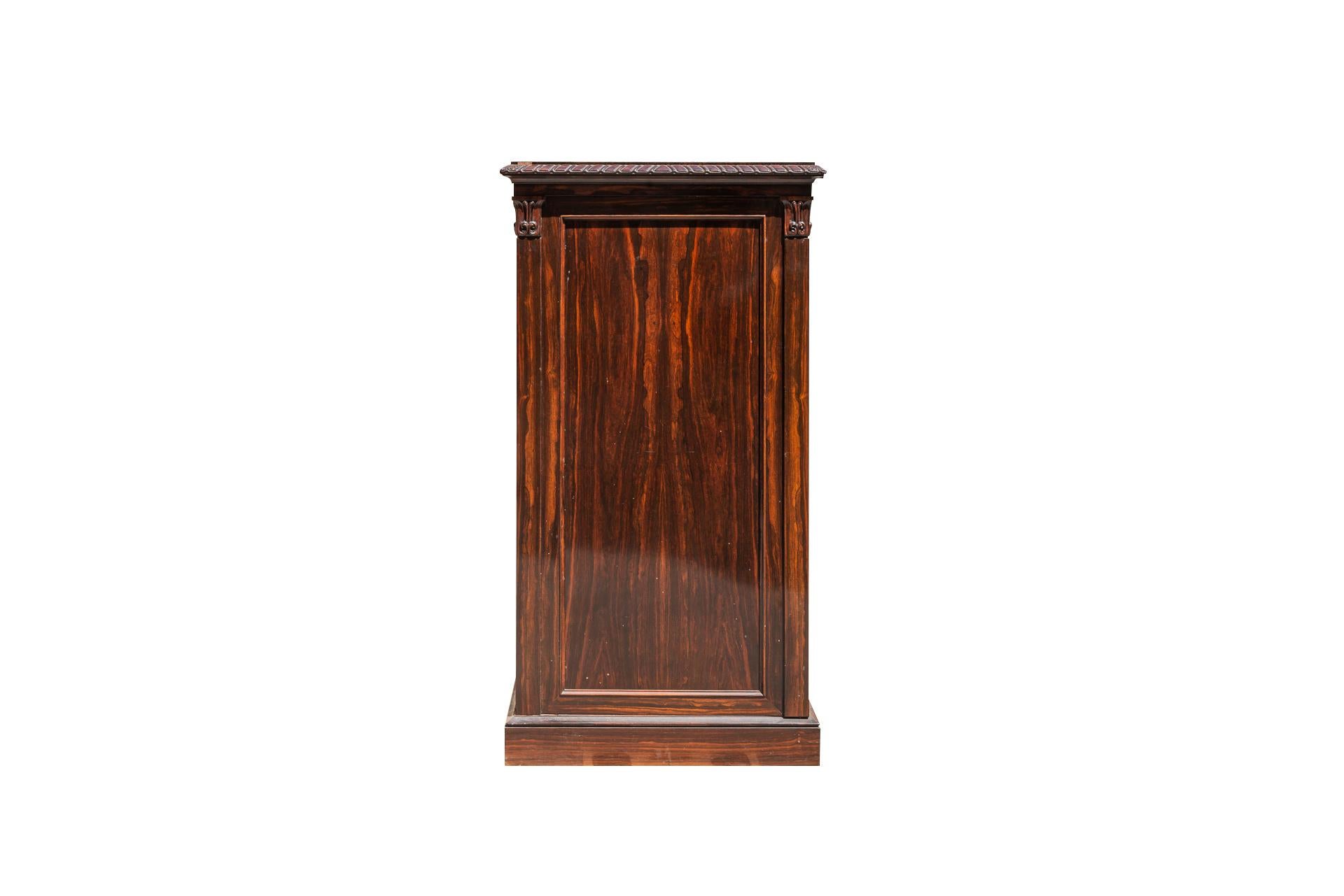 Collector's cabinet, 
Macassar Ebony,
A flap revealing small drawers, sculpted cornice,
Uprights with Corinthian capitals,
circa 1880, England. 

Measures: Height 137 cm, width 73 cm, depth 40 cm.