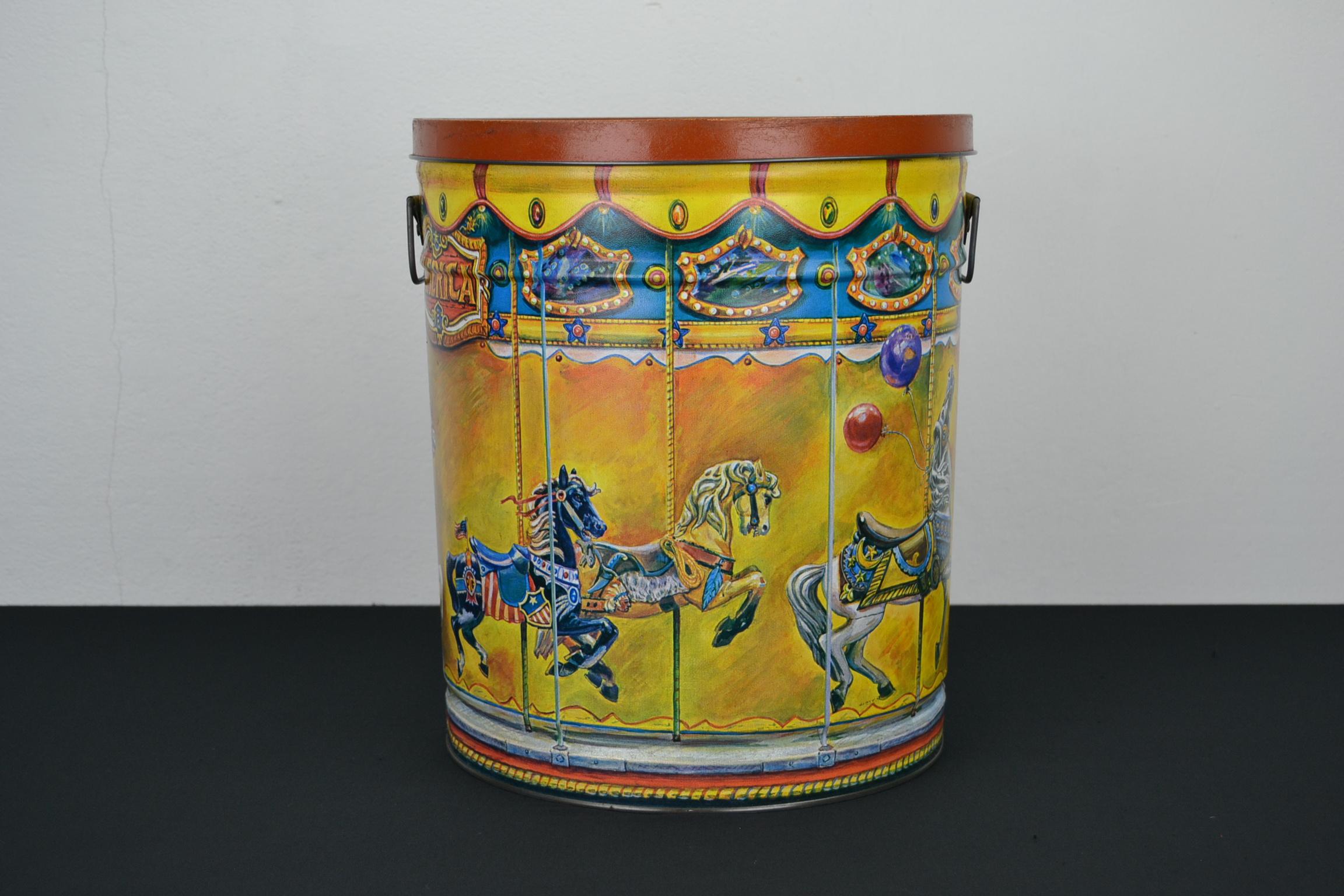 Large tin with carousel horses and animals. 
A tin designed by Mari Pritchard in 1982 and made by Bertels Can Company in 1987. A collector’s Carousel tin with a Dentzel Tiger sculpture and black and white Carousel Horses. The carousel horses are a