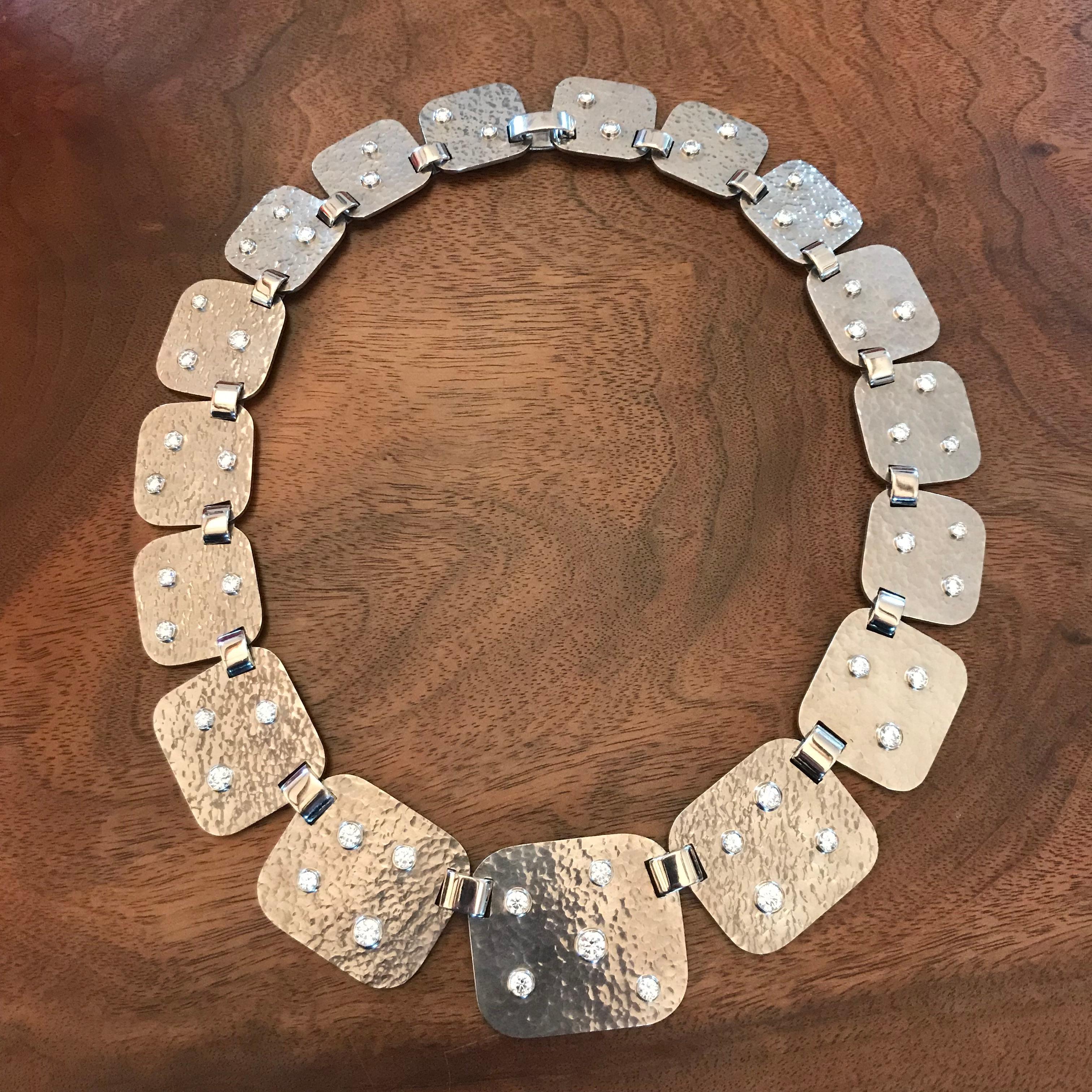 Un extraordinaire collier en or blanc martelé de grande classe avec 51 diamants taille brillant 8,87 ct TW/SI. La taille de chaque segment varie entre 23 et 39 mm.
Ce collier de 46 mm de long est un bijou unique conçu par Colleen B. Rosenblat.
