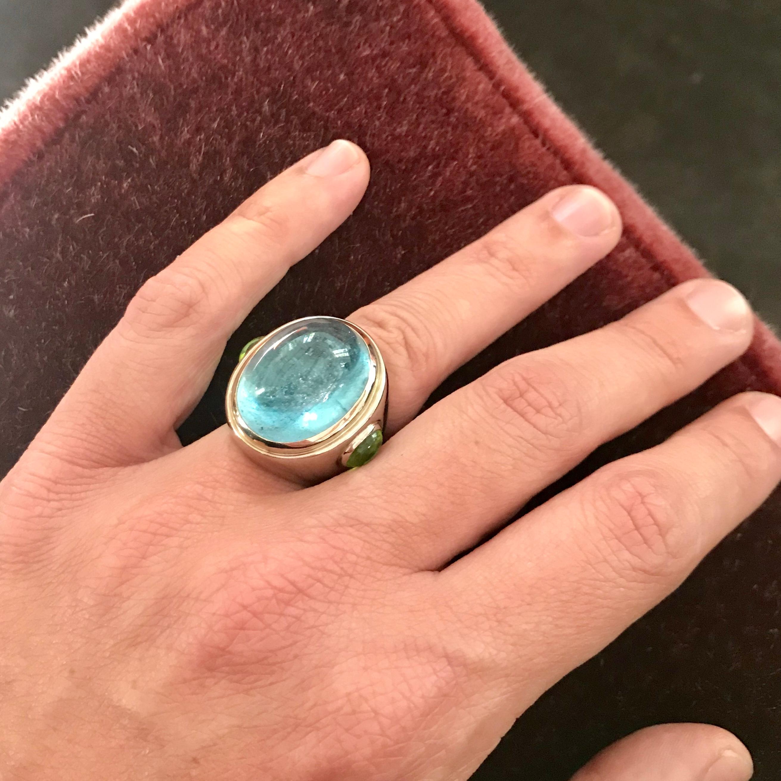 This amazing cocktail ring, set in 18 k white gold, comes along with a huge aquamarine cabochon 30.48 ct and a pair of garden-green peridots cabochons on the sides. Ring size: 57
This eyecatcher was designed by Colleen B. Rosenblat.