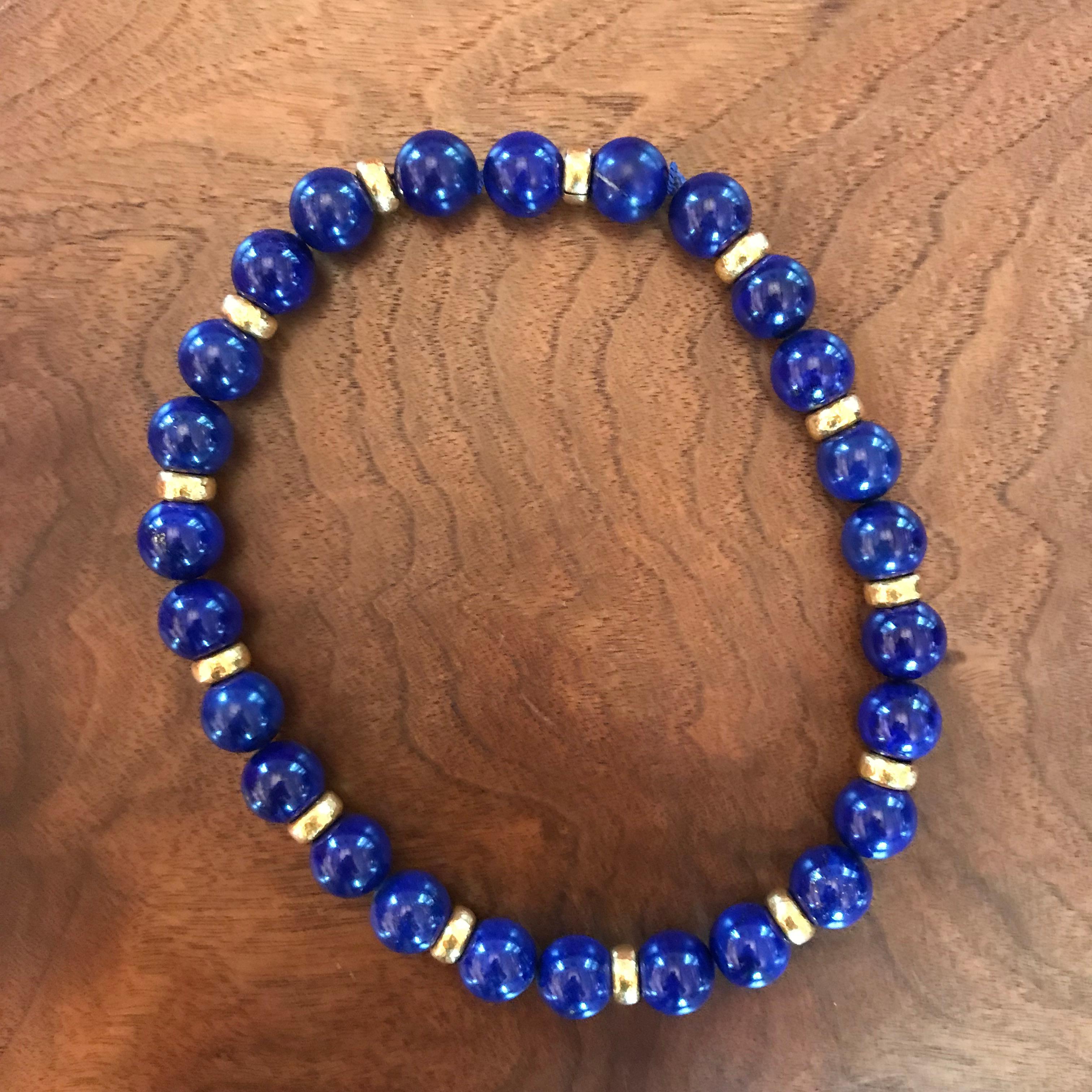 Colleen B. Rosenblat designed this stunning necklace with 26 lapis lazuli with 22k yellow gold hammered gold pieces in between. 
Width of lapis lazuli balls: 15.5 mm