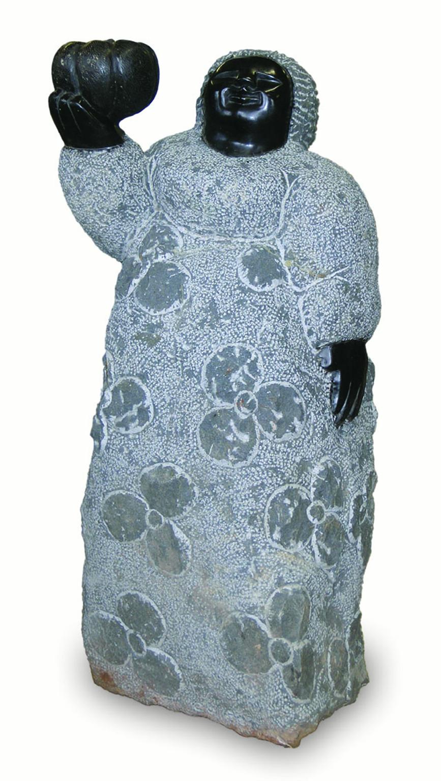 "Mother Holding a Pumpkin" is an original sculpture in black serpentine stone by Colleen Madamombe. The sculpture is a portly woman with a cheerful face holding a large pumpkin in her right hand. It is a wonderful example of Madamombe's mastery of
