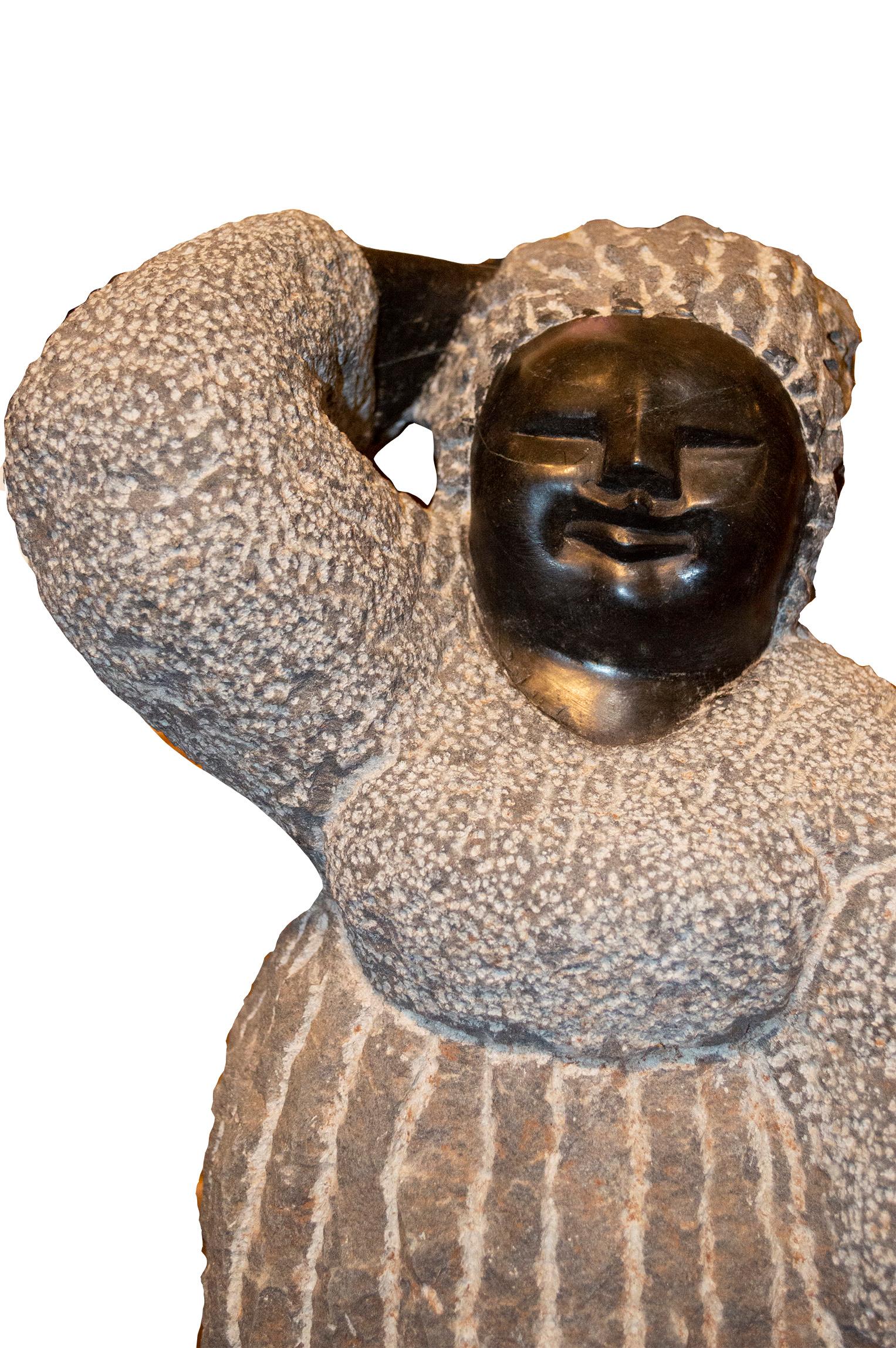 'Preoccupied' is an original black serpentine sculpture by the celebrated second generation Shona artist Colleen Madamombe. The sculpture presents a character common to Madamombe's work: a woman with a round face and wearing a billowing, layered