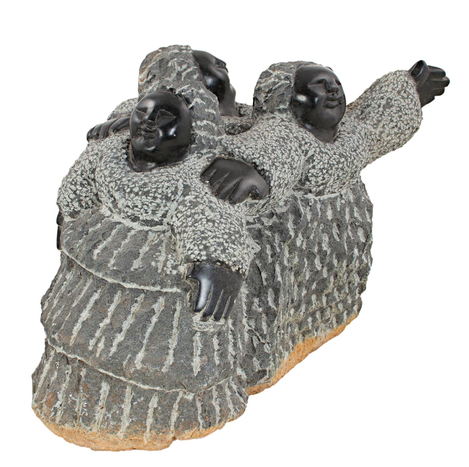 "Trillizos (C-25)" es una escultura original de serpentina negra de Colleen Madamombe. El artista firmó la pieza. Esta obra de arte muestra a tres mujeres con grandes vestidos texturizados, gesticulando y de pie, una cerca de la otra. 

9 1/2" x 13"