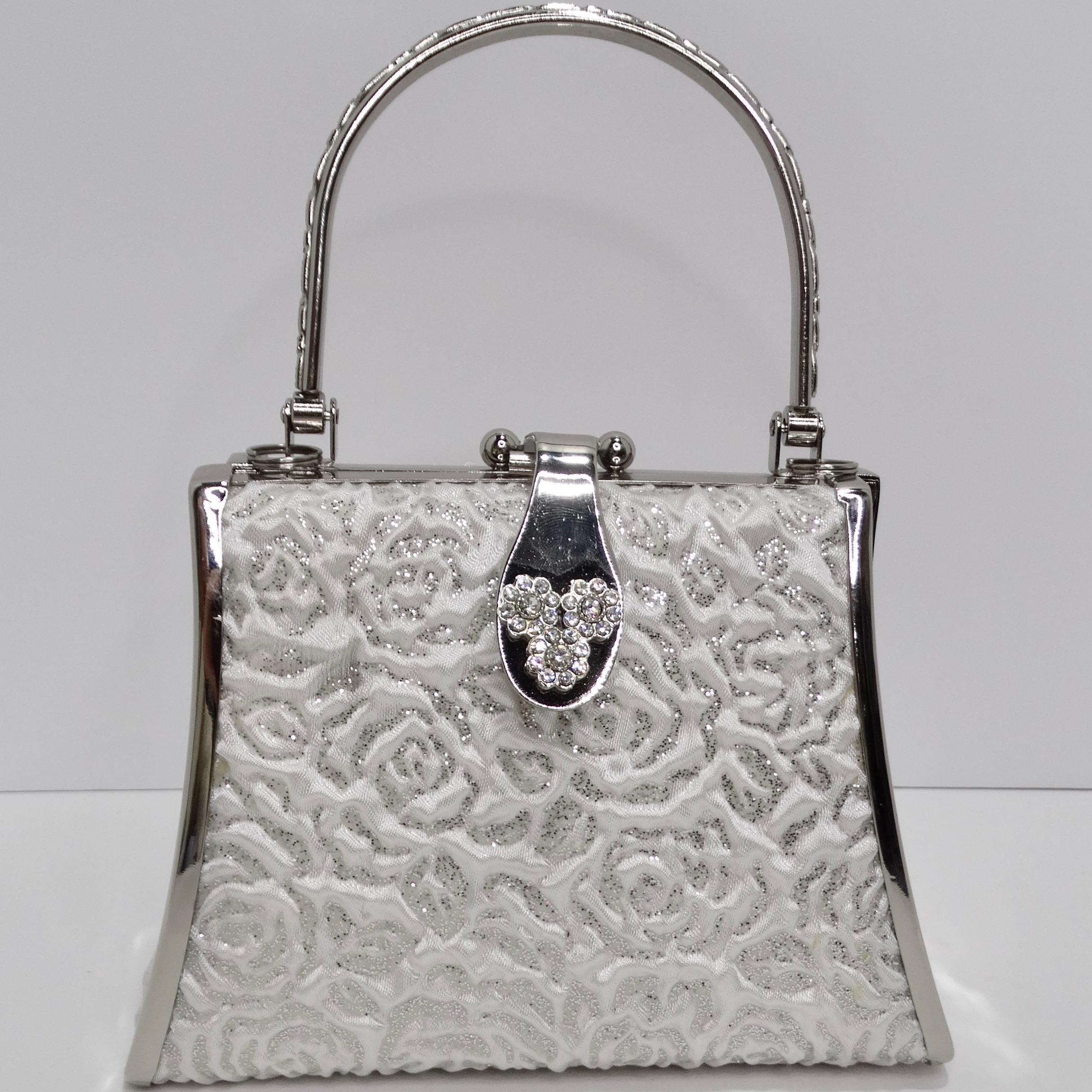 Step back into the glamour of the 1990s with the Colleen Lopez Silver Tone Embroidered Minaudière. This adorable mini handbag is a true fashion gem. It comes with a detachable chain strap, allowing you to switch effortlessly between a clutch and a