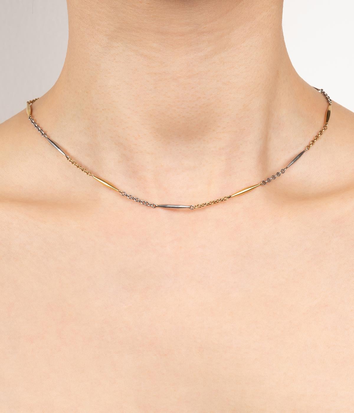 Collier ancien chaîne de montre en or jaune et gris 18 carats (750 millièmes) du début du 20ème siècle.

Poids total du bijou : 11,47 g environ.
Longueur 41,5 cm.
Poinçon tête d'aigle.  
